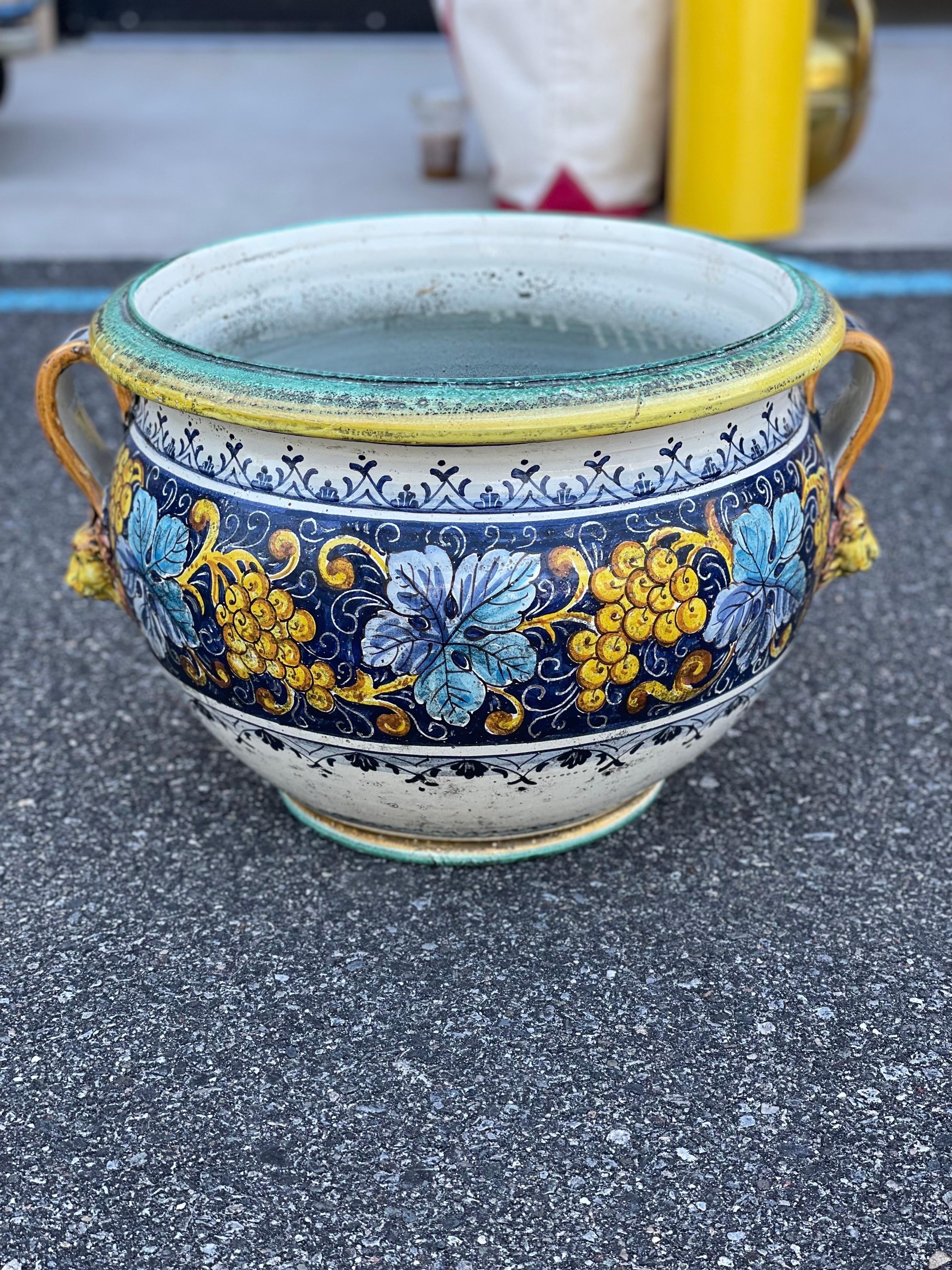 Italian Maiolica painted planter pot.

This is a beautifully hand-painted short stamnos-shaped Maiolica pot. Maiolica is tin-glazed pottery from Italy that has been decorated over a white background. The most defining part of the piece is the lion