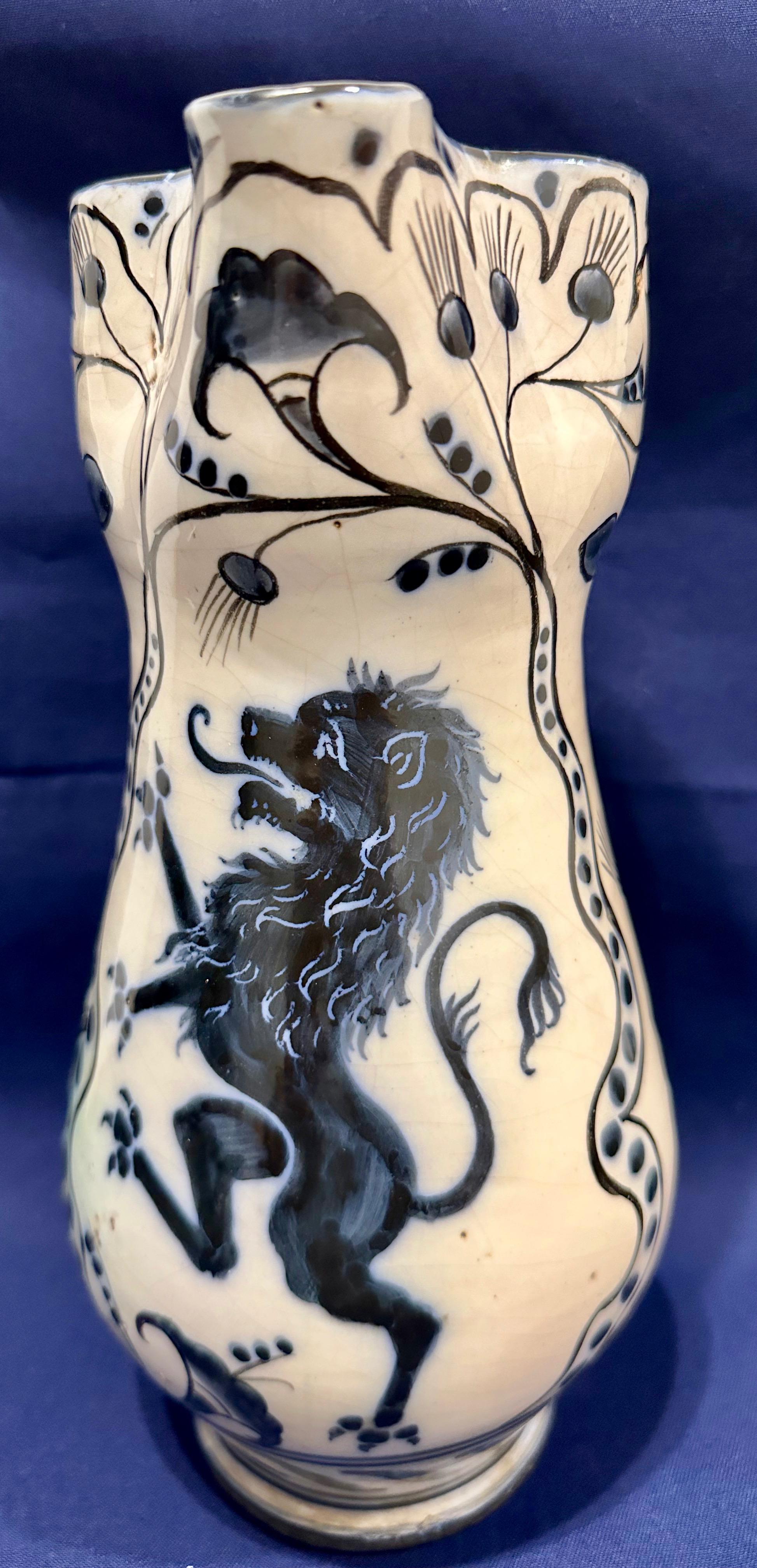 Italienischer Maiolica-Krug mit einem zügellosen Löwen, Mittelitalien, um 1850

Diese nicht gekennzeichnete Maiolica-Kanne mit cremeweißem Hintergrund ist auf der Vorderseite mit einem kobaltblauen, aufgerichteten Löwen verziert. Die übrige