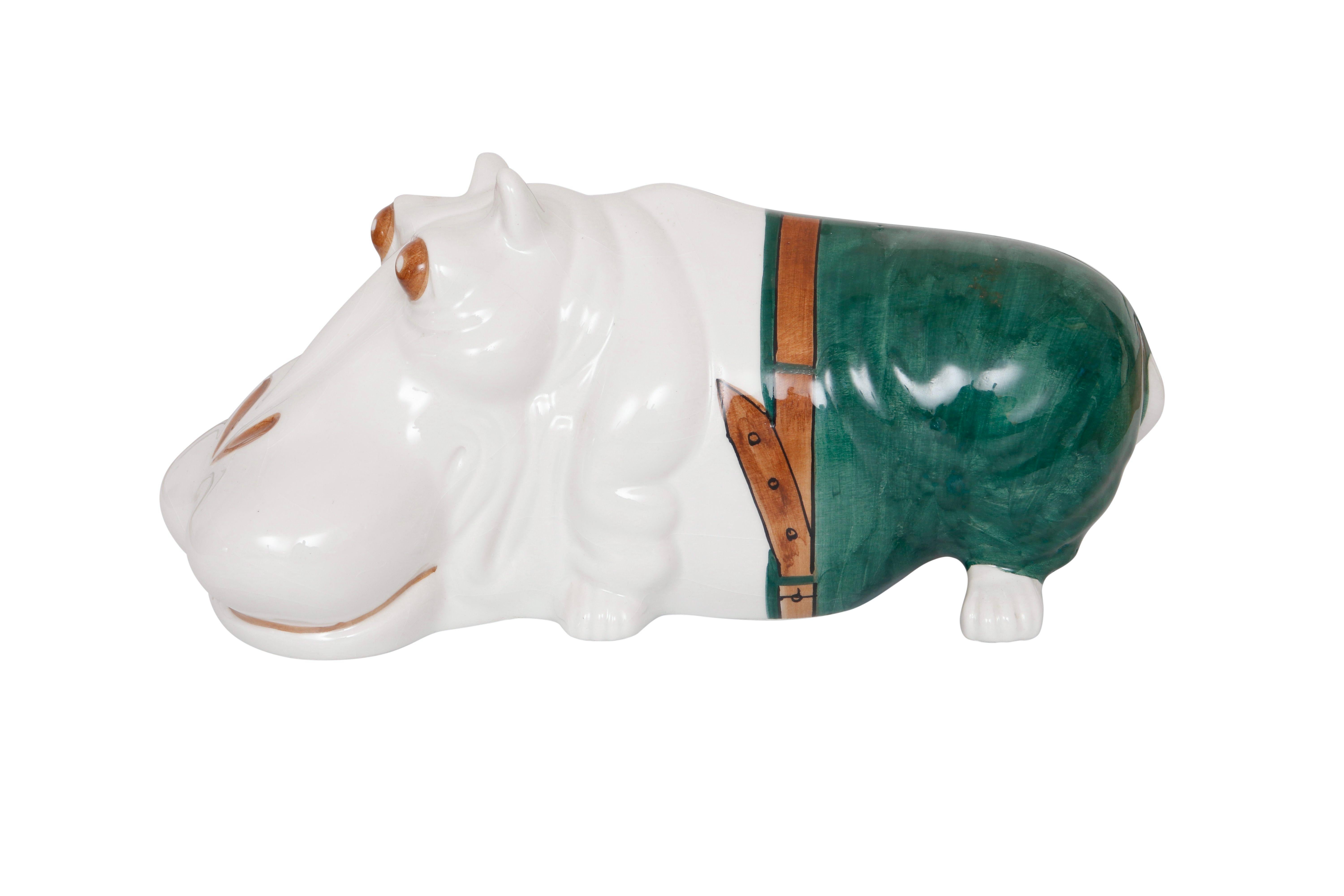 An Italian majolica hippopotamus in white decorated with green trousers, a brown belt and brown details on the face. Marked underneath 