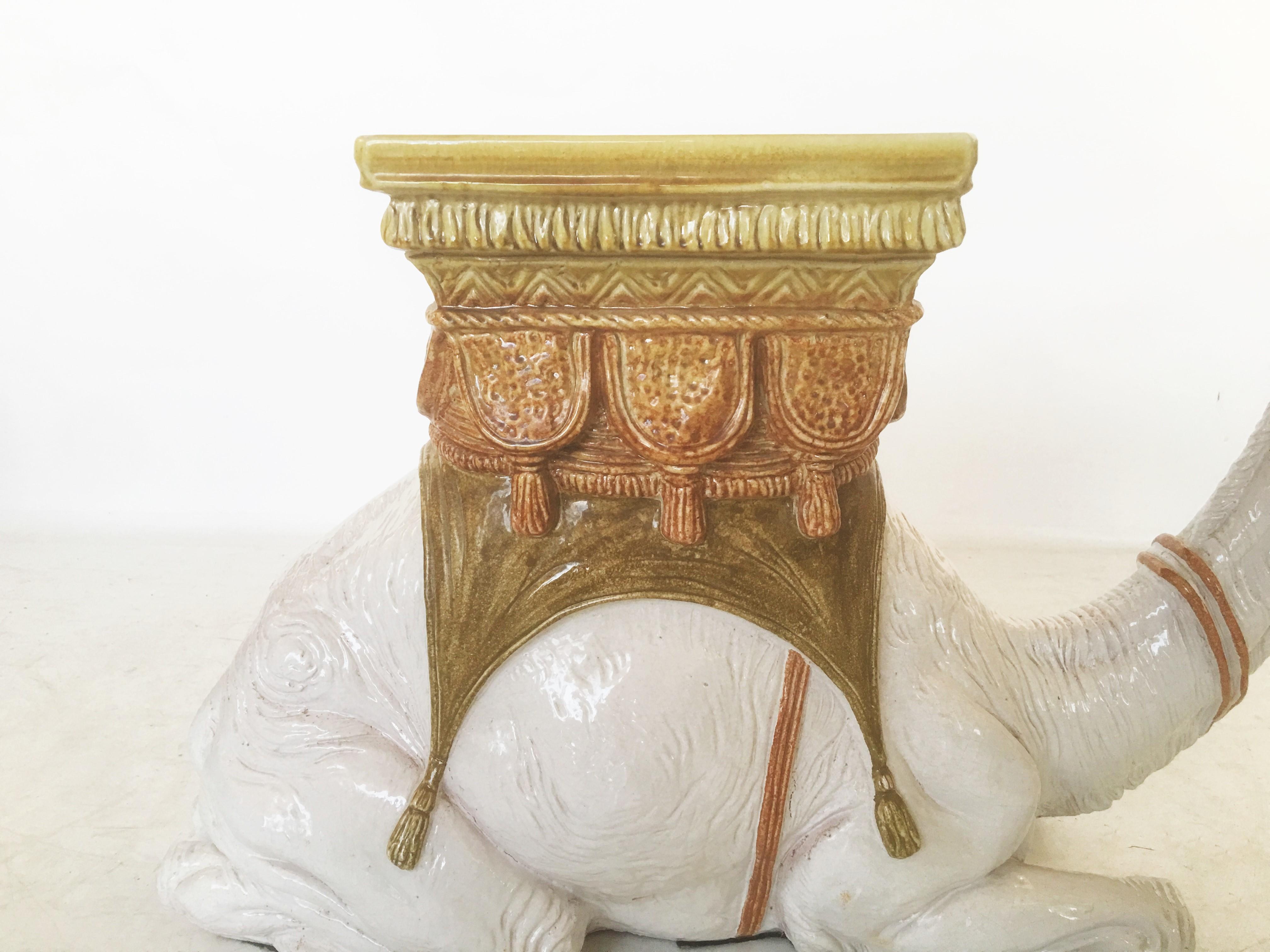 Charming vintage hand painted Italian drinks table or garden seat in the shape of a white kneeling camel. Between its humps is a decorative saddle with yellow, orange and green details. Works well as a side table or even a plant stand. The camel