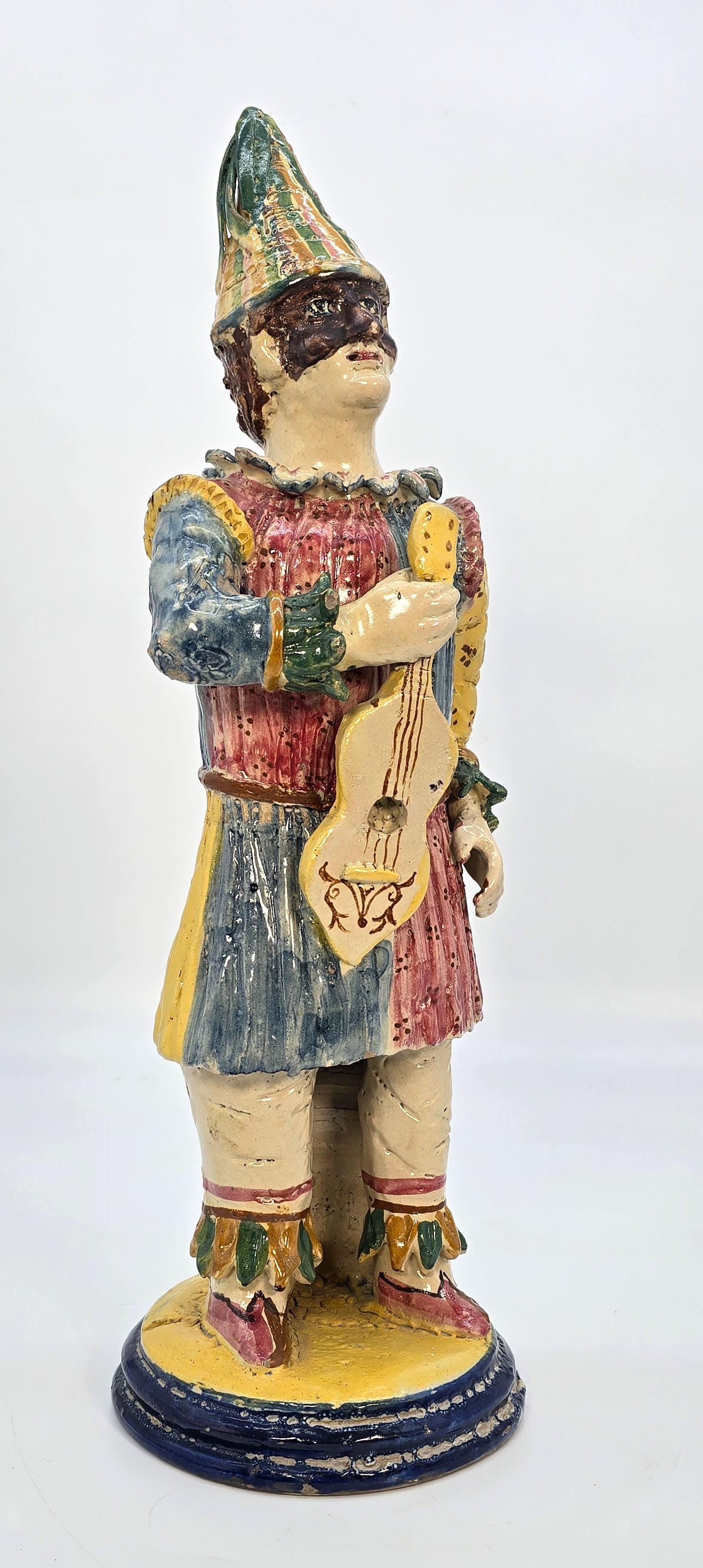 This superb, large, and highly decorative late 19th-century Italian naïve majolica pottery figure is hand modelled in clay, which is painted and glazed in bold colours.

It depicts the traditional figure of Pulcinella, a clown-like entertainer from
