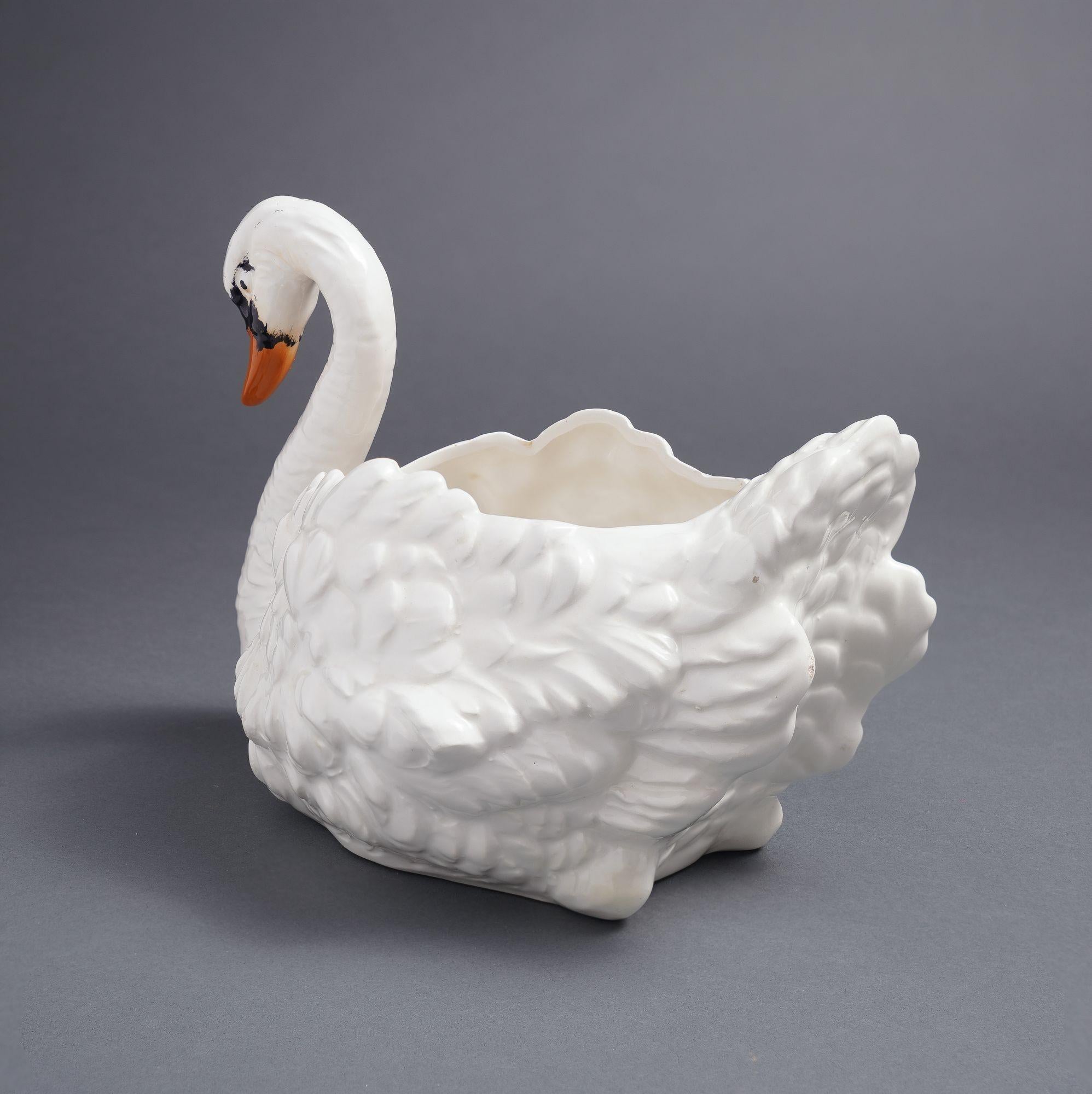 Majolica swan vase or jardiniere. The arched neck swan is detailed with an orange beak and partially black face. The back of the swan is open creating a reservoir for plants or flowers.

Italy, circa 1900-1920.