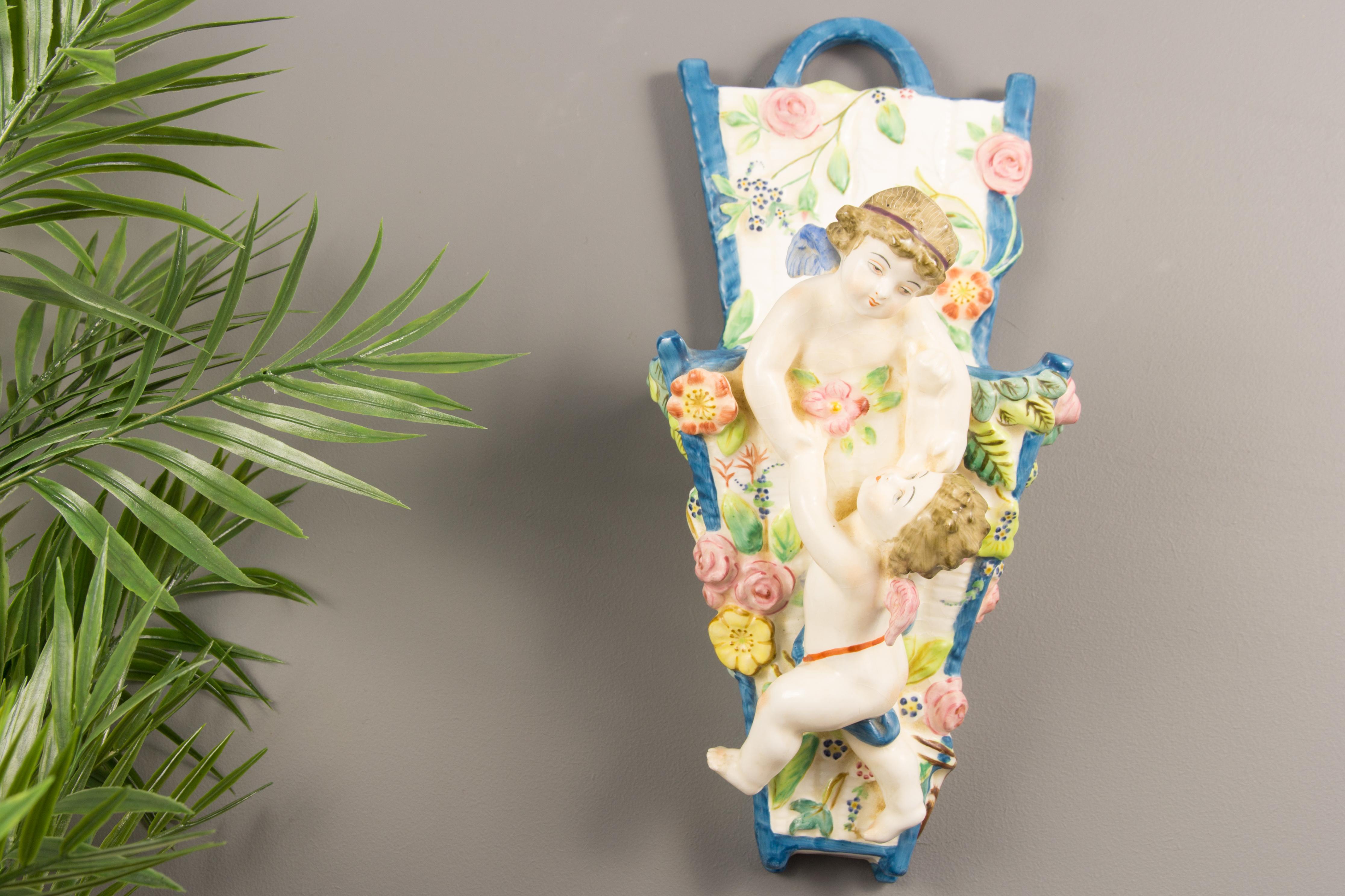 Beautiful Majolica wall pocket or vase decorated with hand painted cherubs and flowers. Made in Italy, 1950s.
Measures:
Height 30 cm / 11.81 in, width 15 cm / 5.9 in, depth 15 cm / 5.9 in.
    