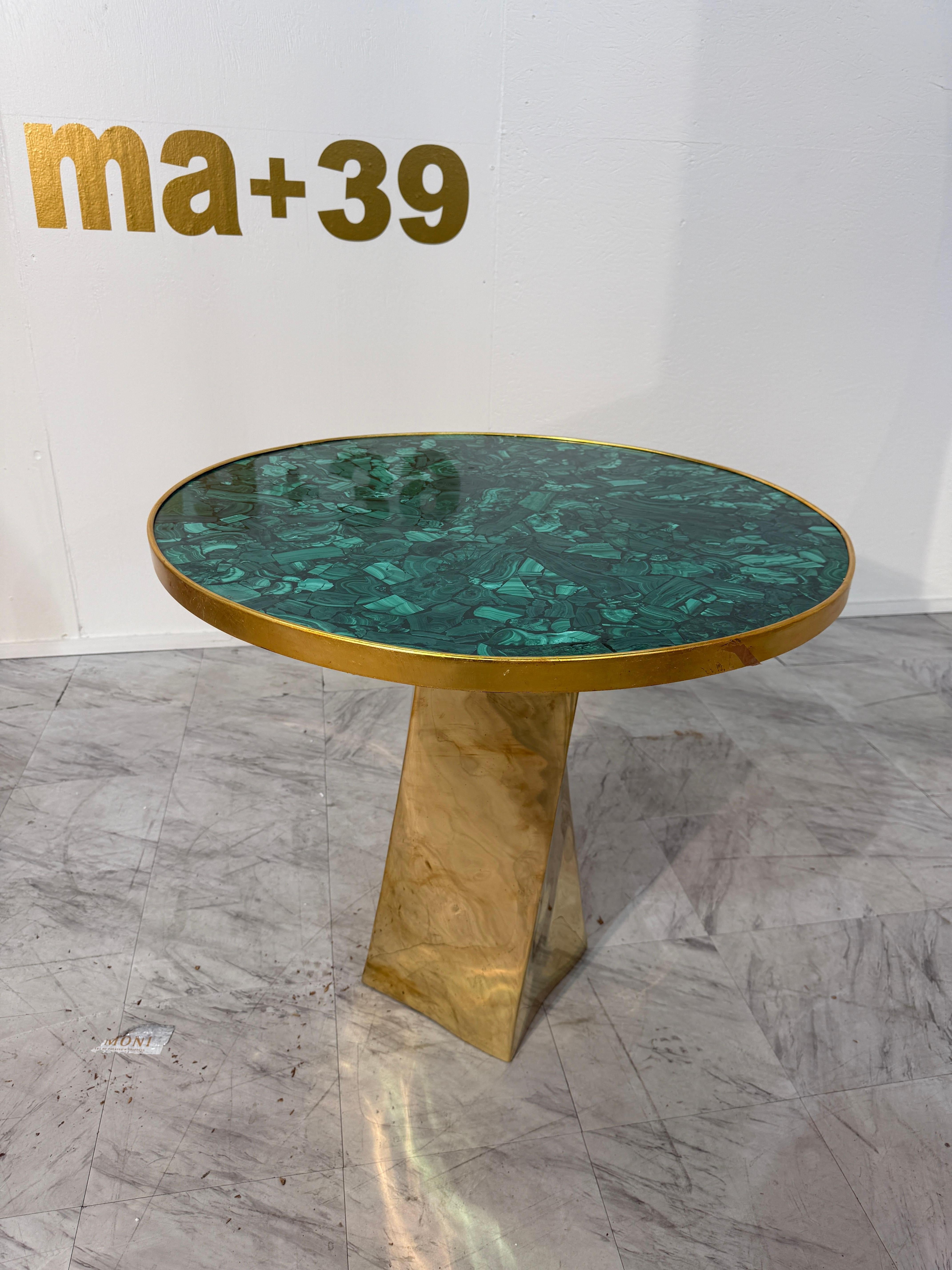 Eccezionale espressione di artigianato scultoreo, questo tavolo della Fonderia Artistica Ruocco mette in mostra un raffinato gioco di forme, materiali, movimento e ritmo visivo. Il piano circolare è realizzato in malachite verde riccamente venata,