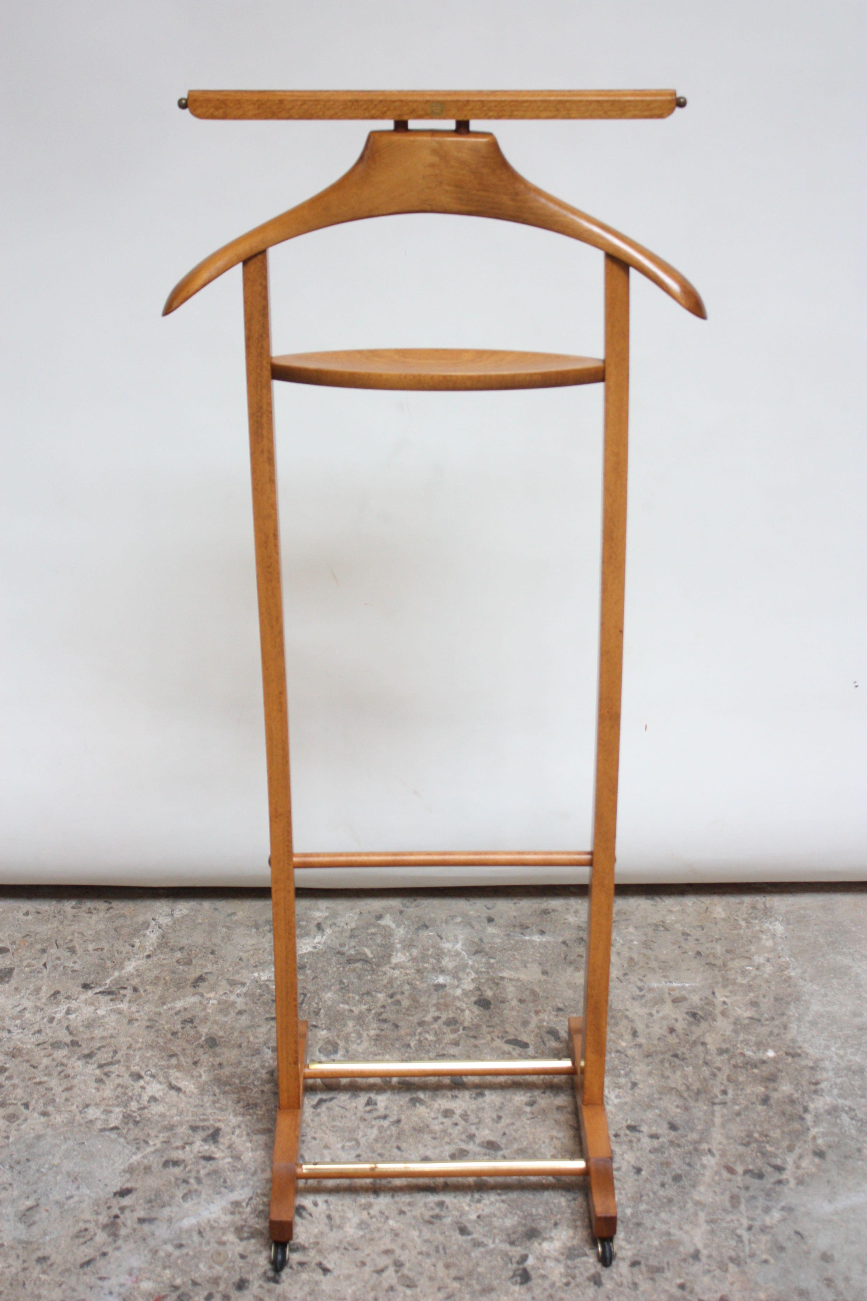 This Italian maple valet was designed by Fratelli Reguitti in the 1950s. Composed of a frame/hanger and change or cufflink holder with a double rack on the bottom for shoes and four caster wheels for easy mobility. The top bar (intended for hanging