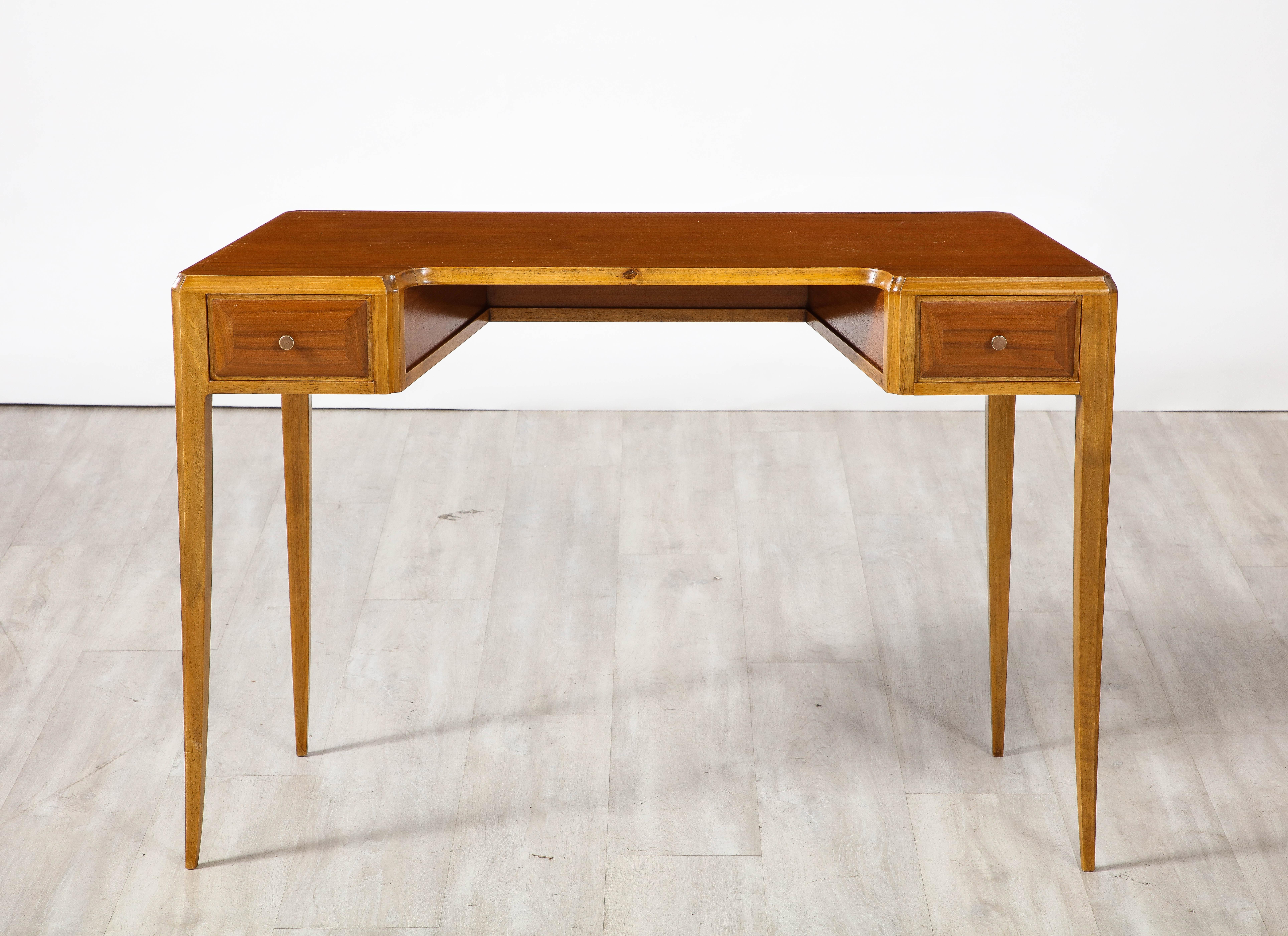 A fine Italian maple wood writing desk, with two small drawers on the front apron; elegantly tapered legs; the whole finished all around so may be placed anywhere in a room.  Highly sculptural and classic. 

Italy, circa late 1940's 
Size: 29