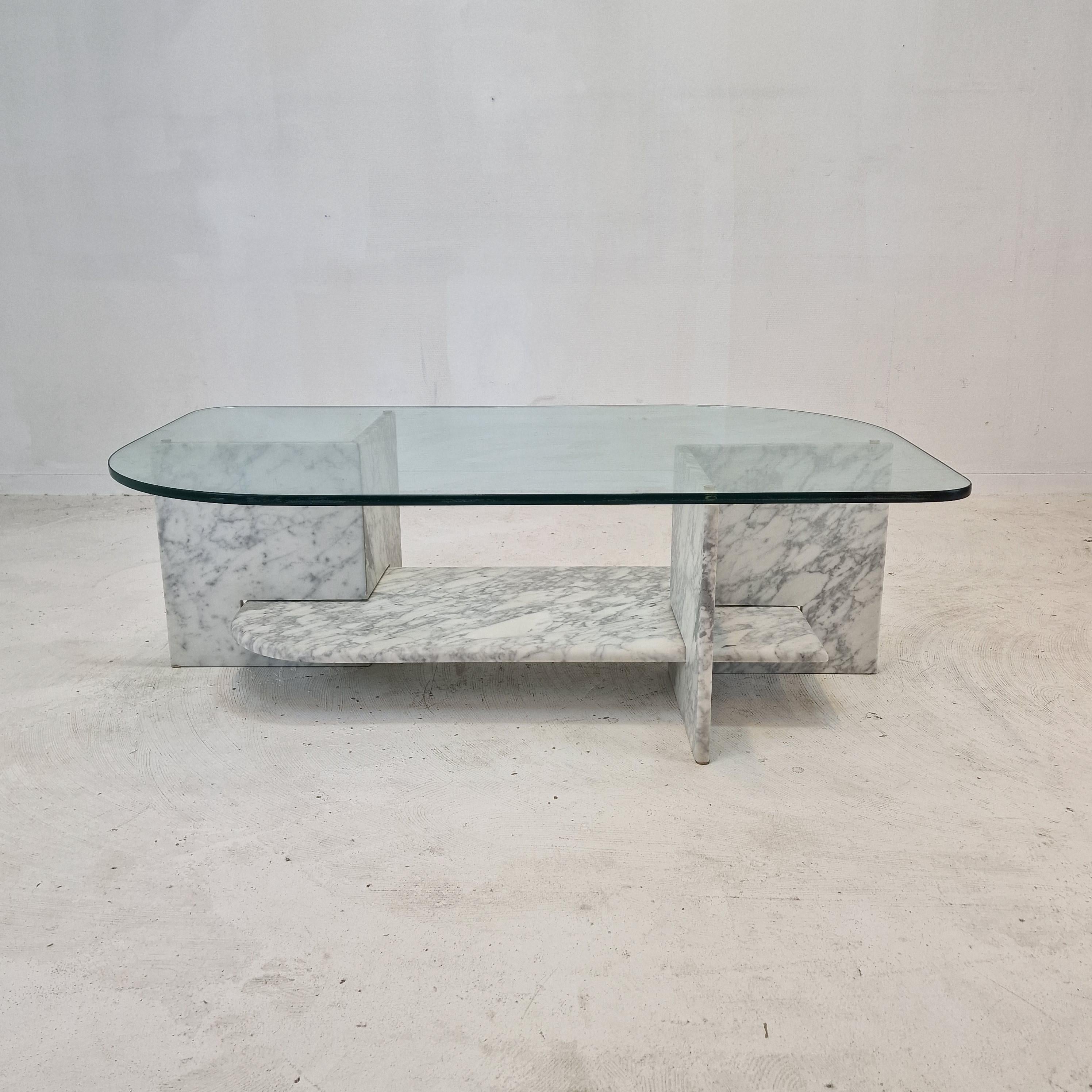 Stunning Italian coffee table handcrafted out of marble and glass, 1980s.

The rectangle plate and the two feet are made of very beautiful marble.
The fabulous marble features a very nice pattern of different colors.
The top is made of