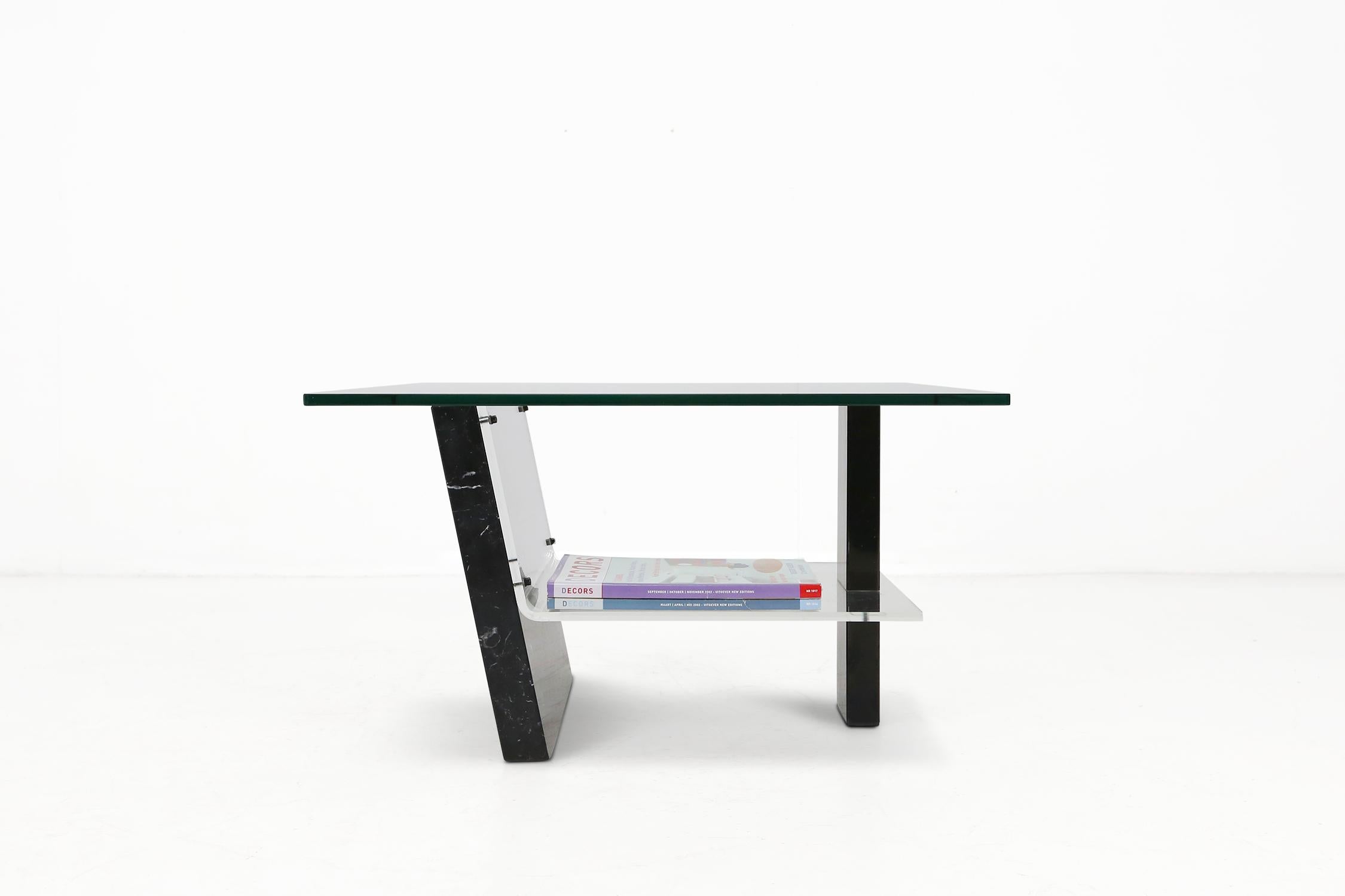 Italian coffee table made of a black marble base with plexiglass and a glass top.