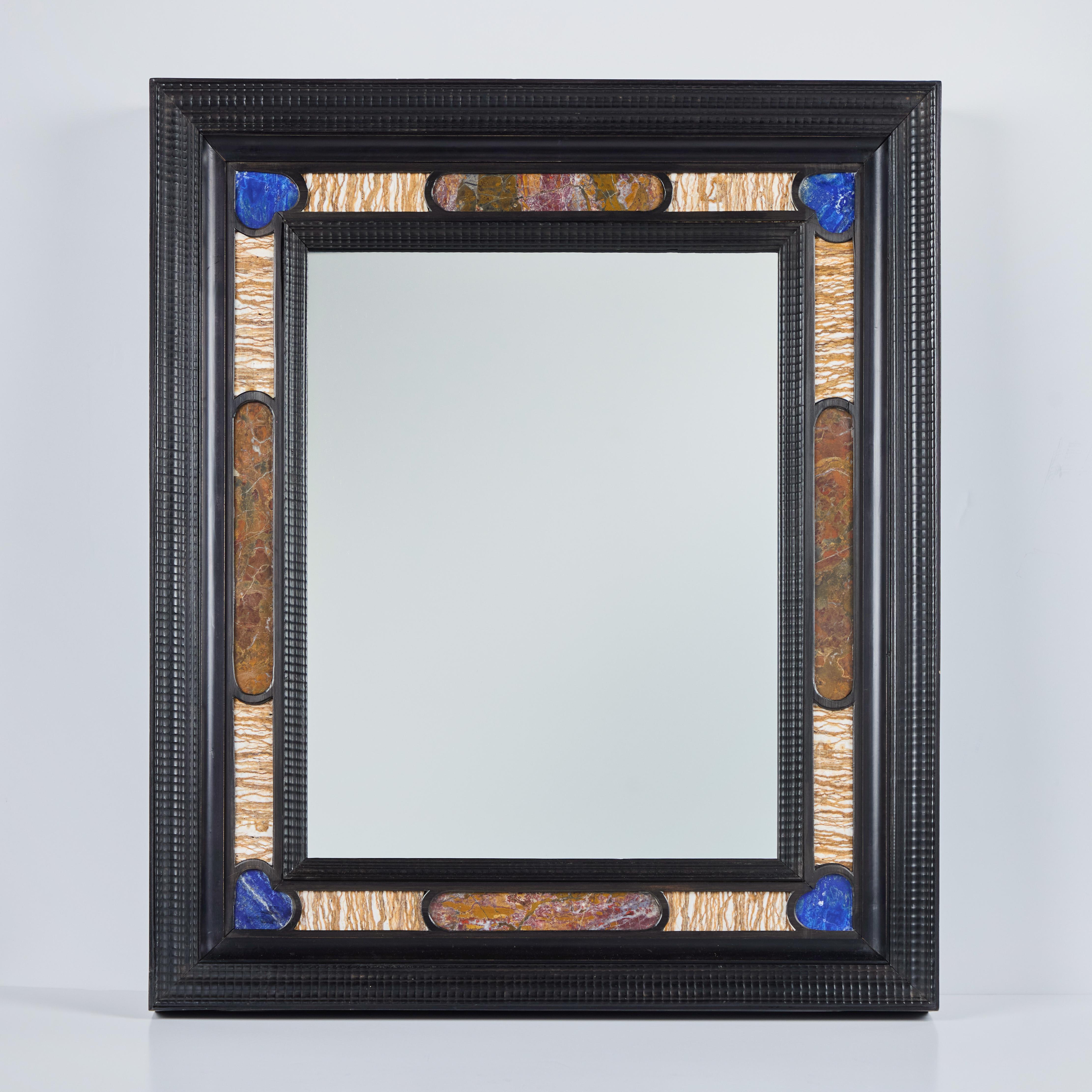 A handsome, ebonized wood framed mirror with marble and lapis veneer insets.  There is a hook for hanging and shown in the photo of the back side of the mirror.