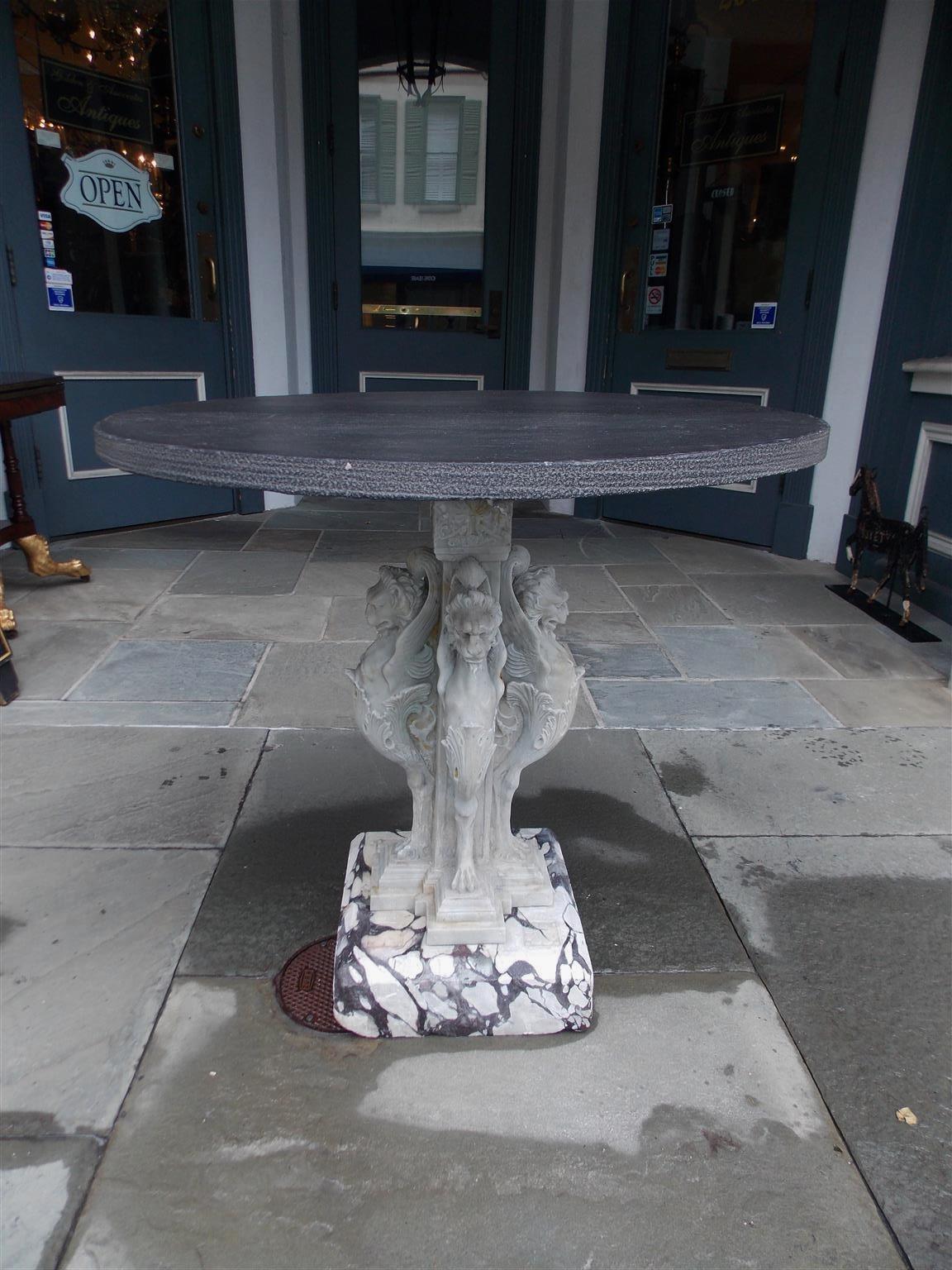 Italian marble and circular slate top griffon and floral medallion garden table, Early 19th century.