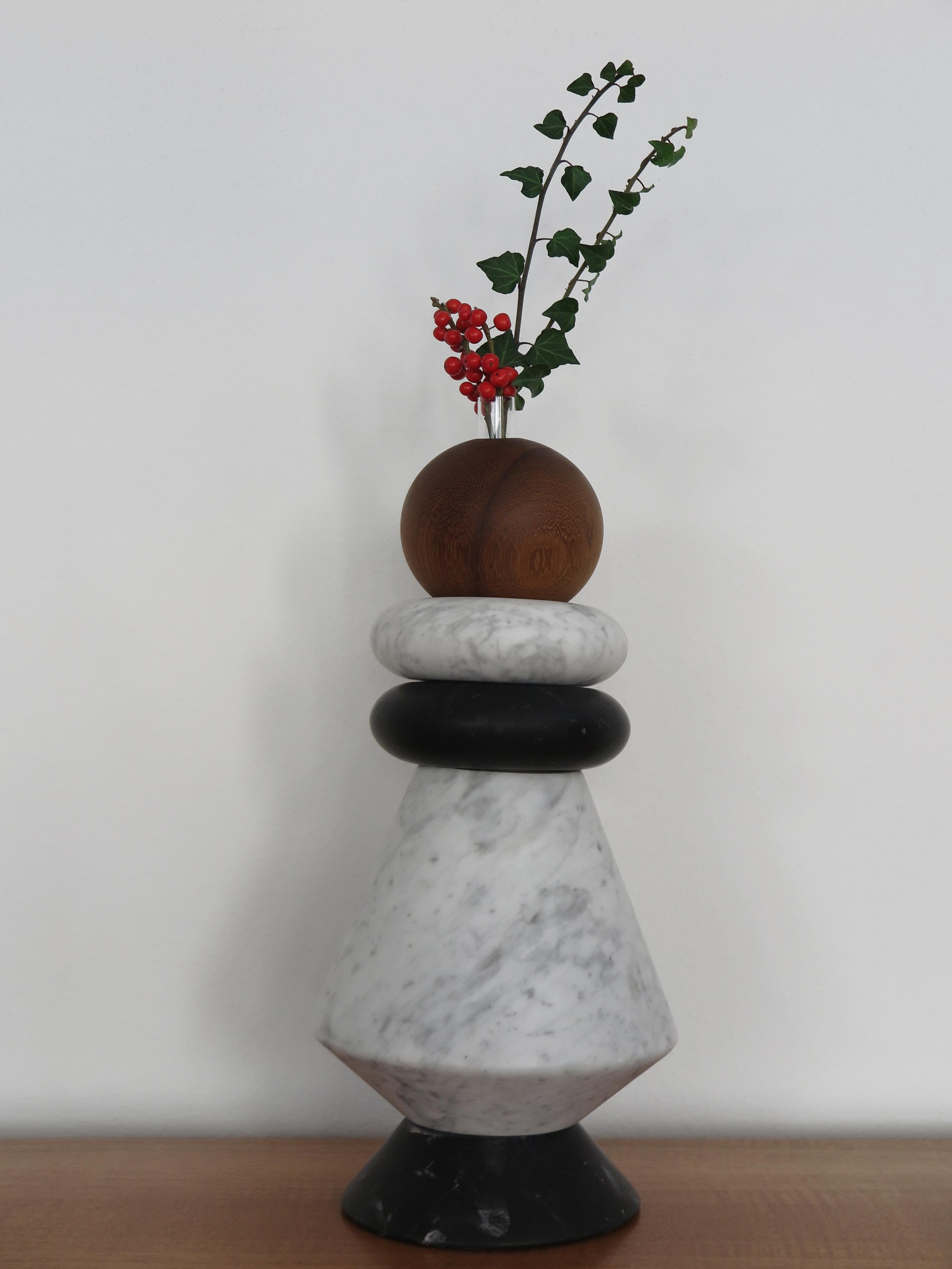 Sculpture contemporaine italienne, bougeoir et vase à fleurs, modulable à volonté en marbre blanc de Carrare, marbre noir, et bois massif avec inclusion de deux vases en verre pour fleurs fraîches.
Les différents éléments peuvent être composés et