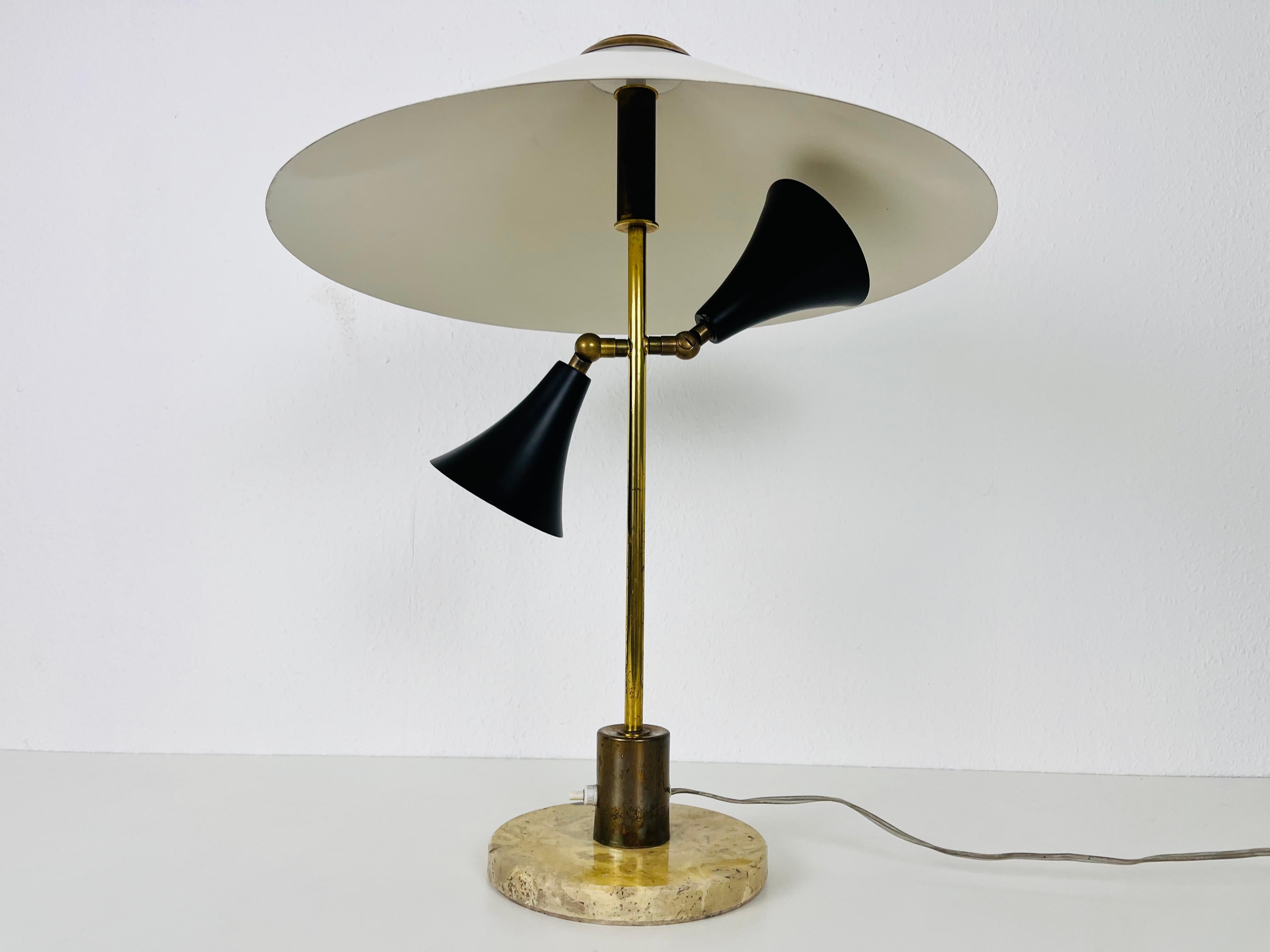 An Italian table lamp made in the 1960s. The lighting has an exceptional design which is similar to the table lamps made by Stilnovo. It is made of brass with a beautiful metal element. The base is made of solid marble.

The light requires one E27