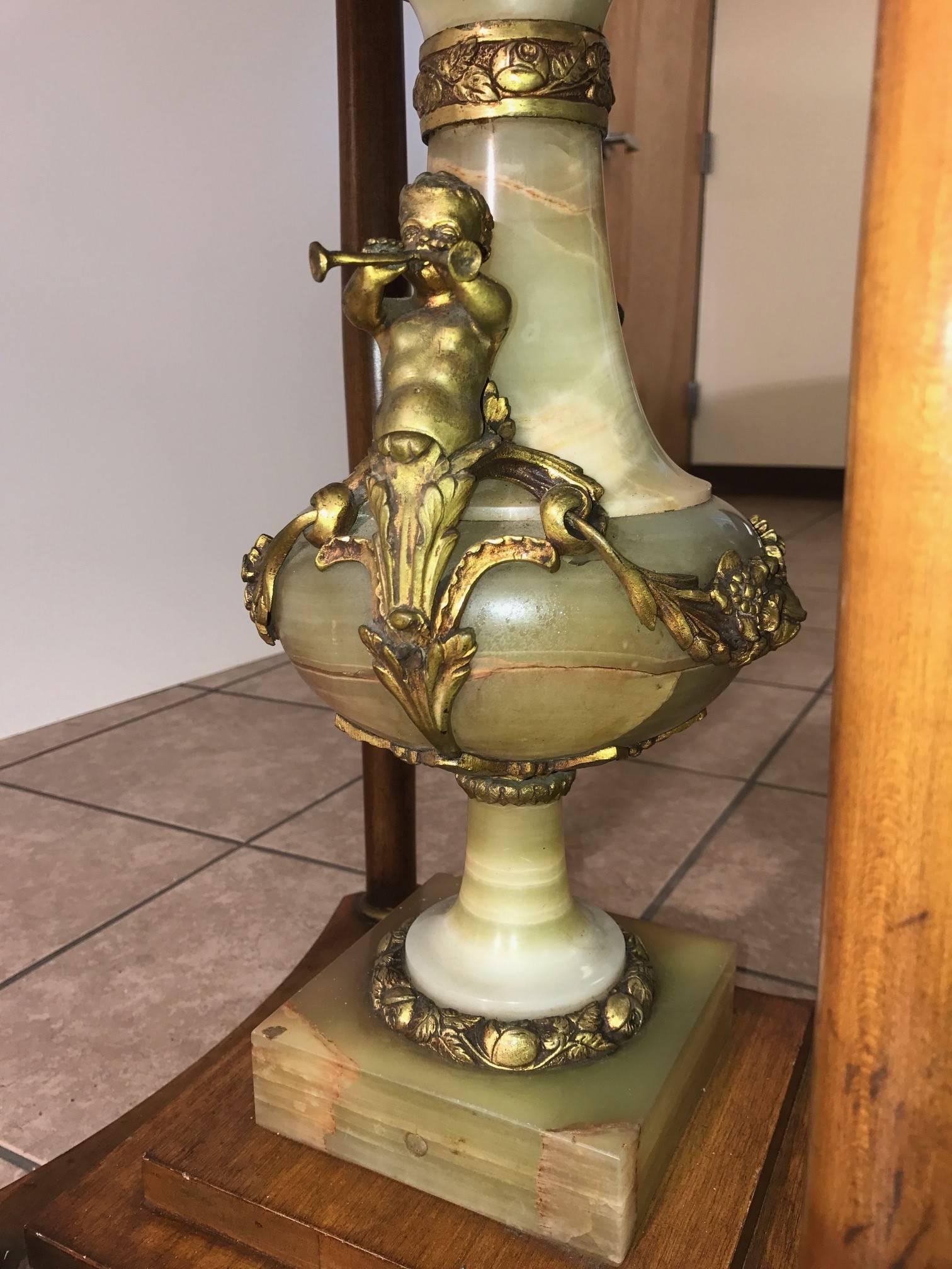 Stunning antique Italian center table with a marble top, onyx pedestal with bronze cherubs. The table has a wood base and is well designed table.
