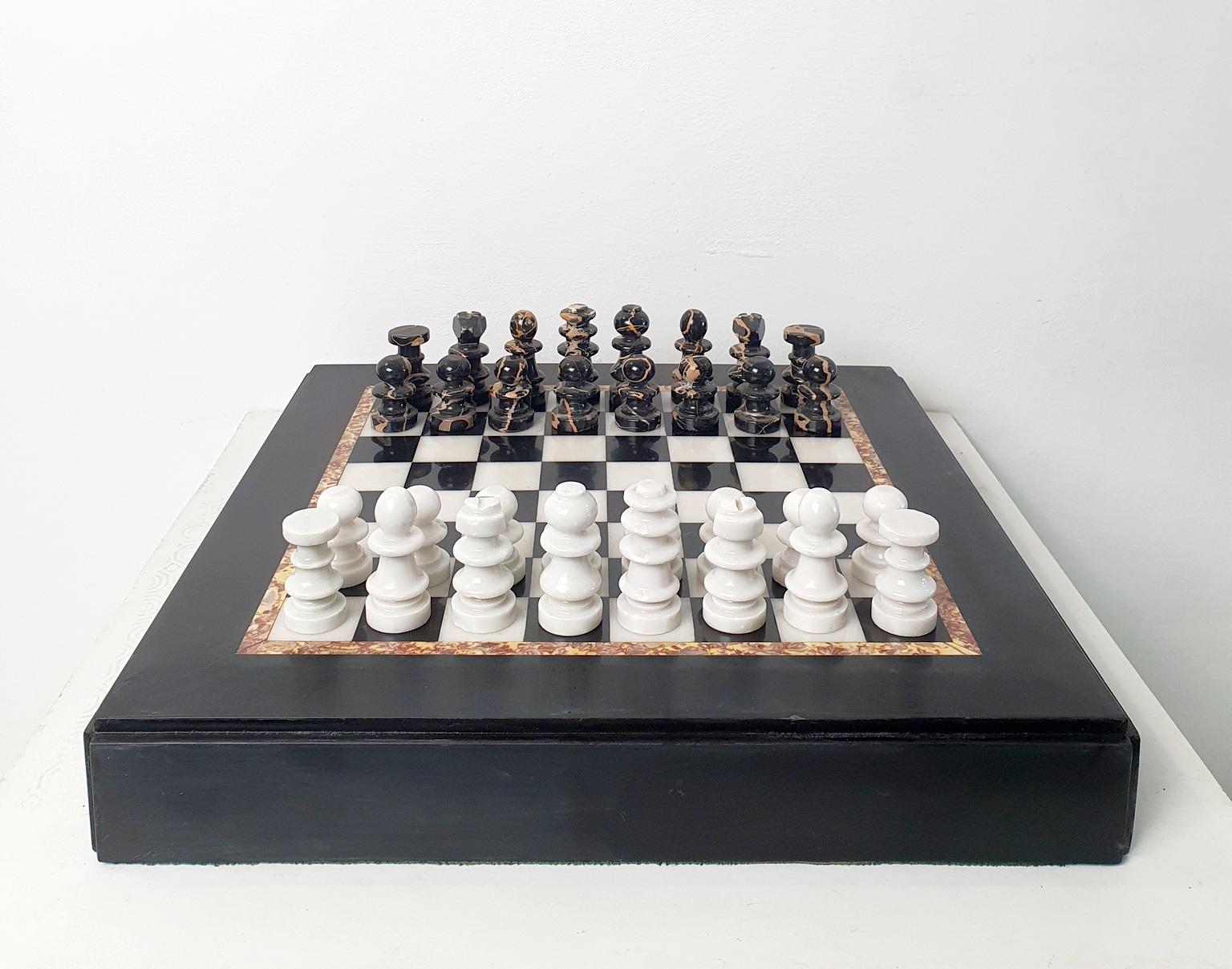 Classic chess board in black and white marble with chess pieces to match in white and black marble as well. 