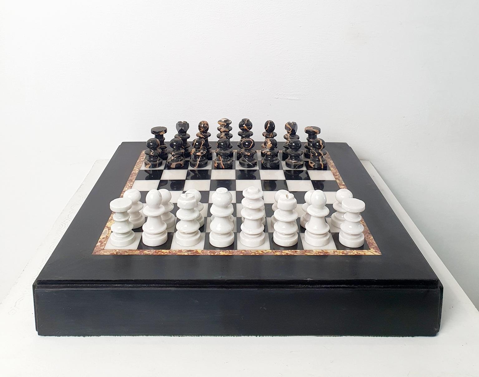 Échiquier classique en marbre noir et blanc avec pièces d'échecs assorties en marbre blanc et noir également. 