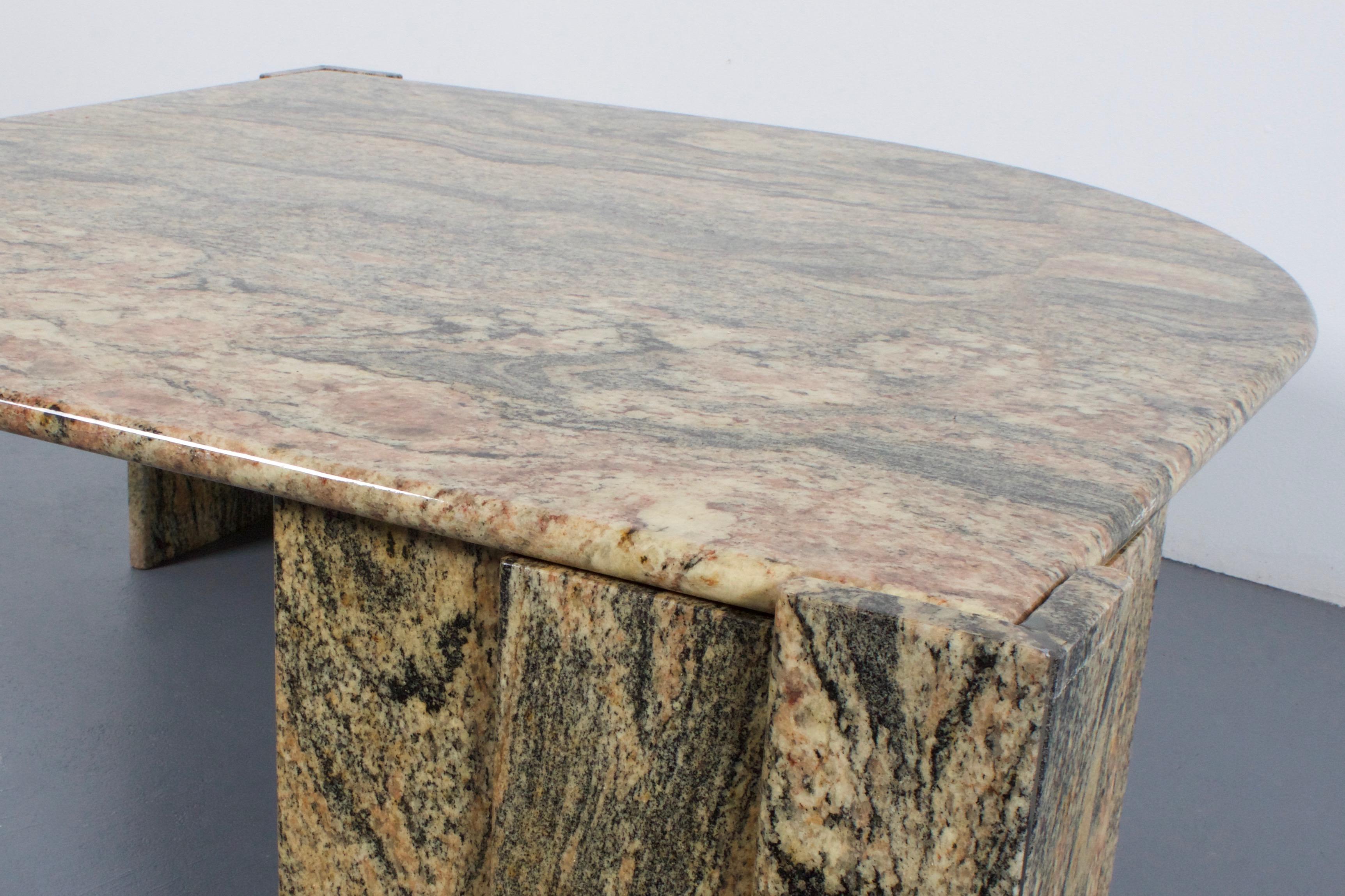 Italian marble 1970s coffee table in good condition.

Beautiful grey, beige and pink marble.

The heavy eye-shaped top rests on two triangles which are build up out 
of three layers of solid marble.

We offer a variety of insured shipping services,