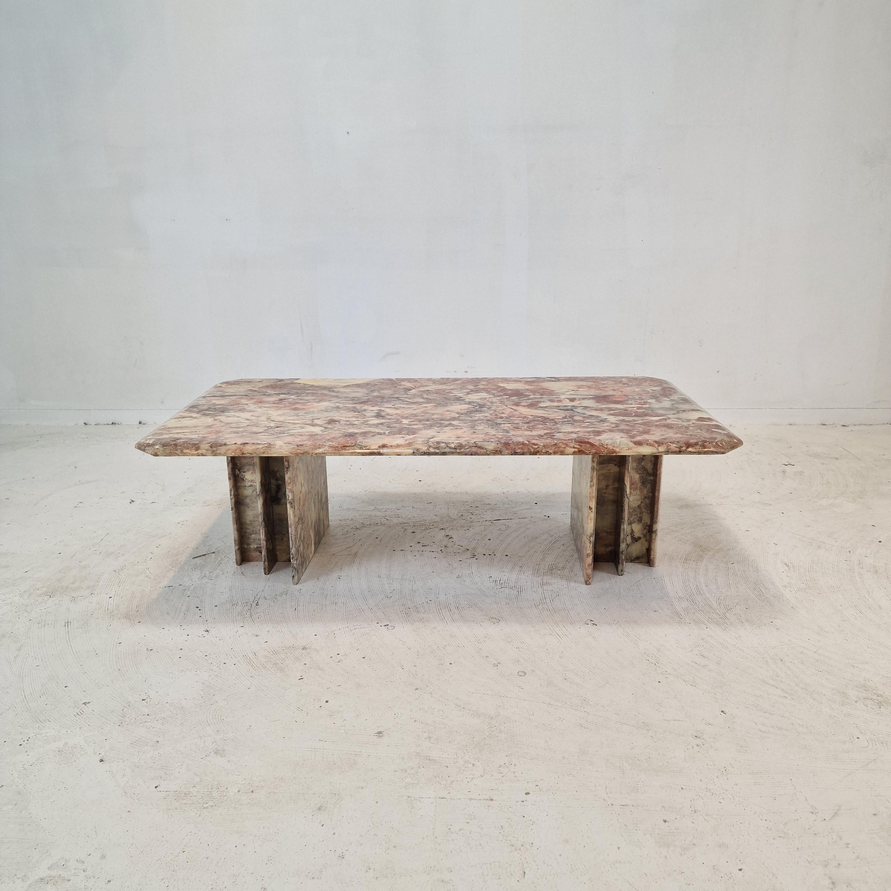 Very nice Italian coffee table, fabricated in the 1980s.

It is handcrafted out of very beautiful marble.
The fabulous marble features a very nice pattern of different colors. 

It is possible to vary the position of the feet.

It has the normal