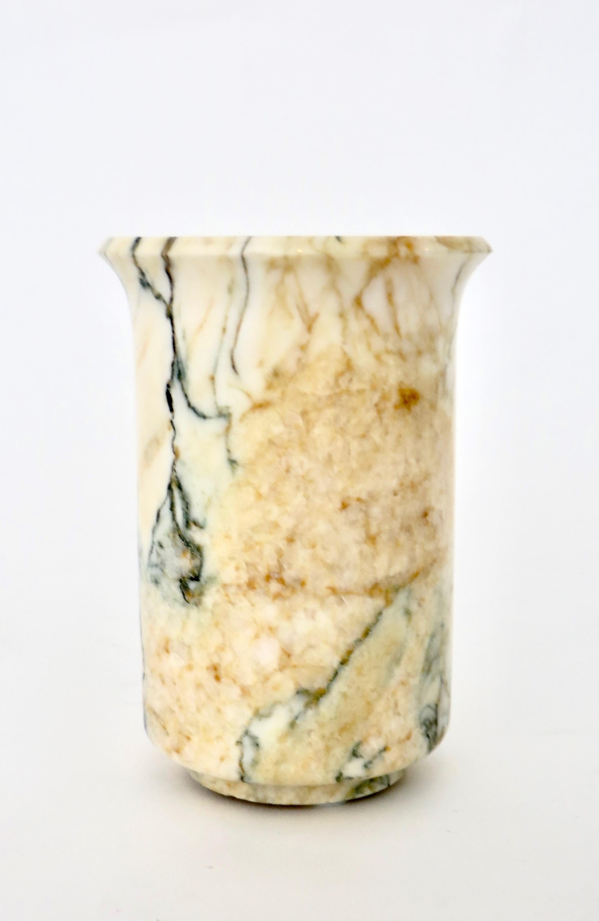 Italian polished marble vase in creams and gold with blue black green veining.
  