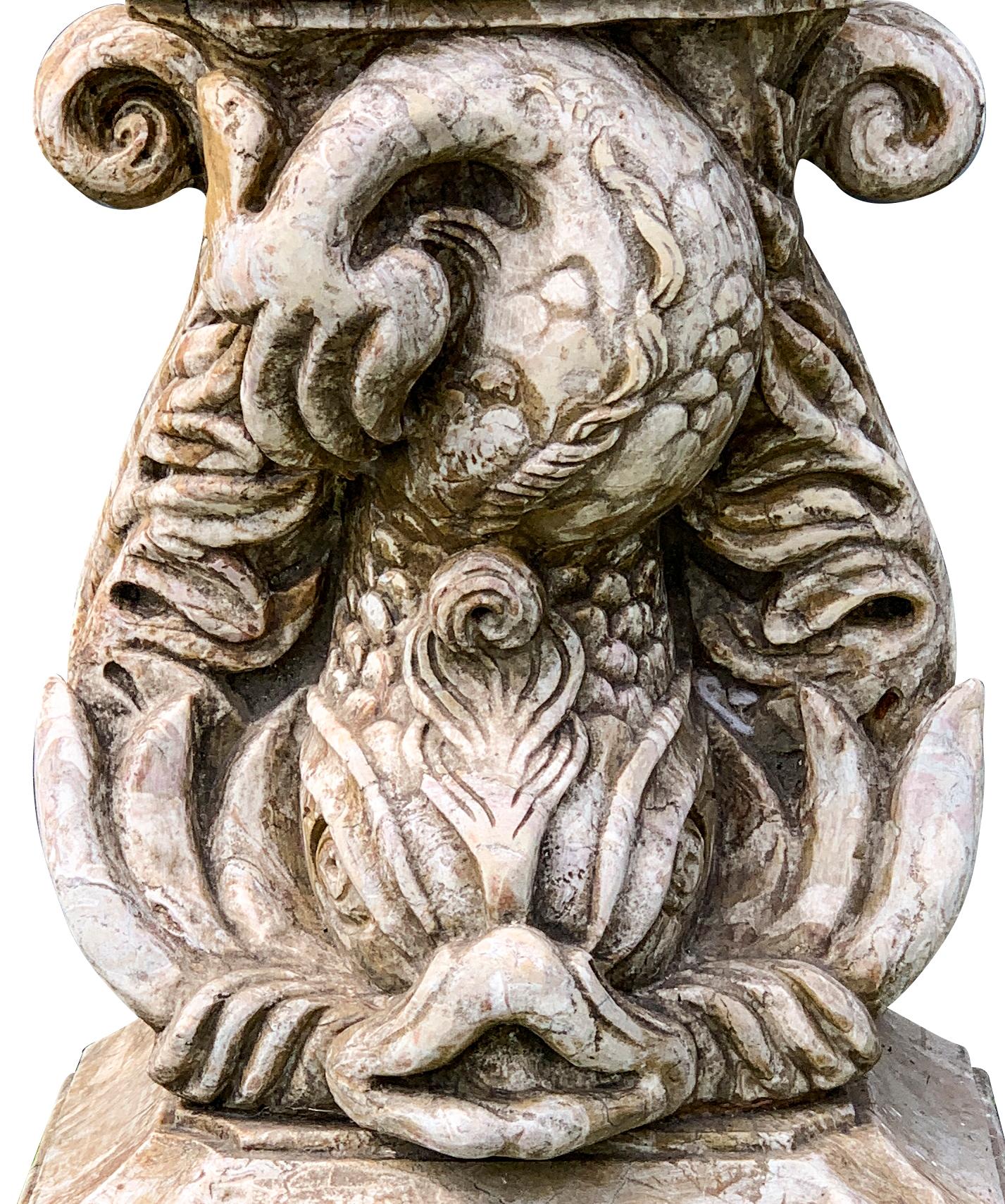With a arched back panel with cherub pouring water from an urn surrounded by cattails over a basin with shaped rim and gadrooned underside supported on a carved dolphin form support and plinth base.