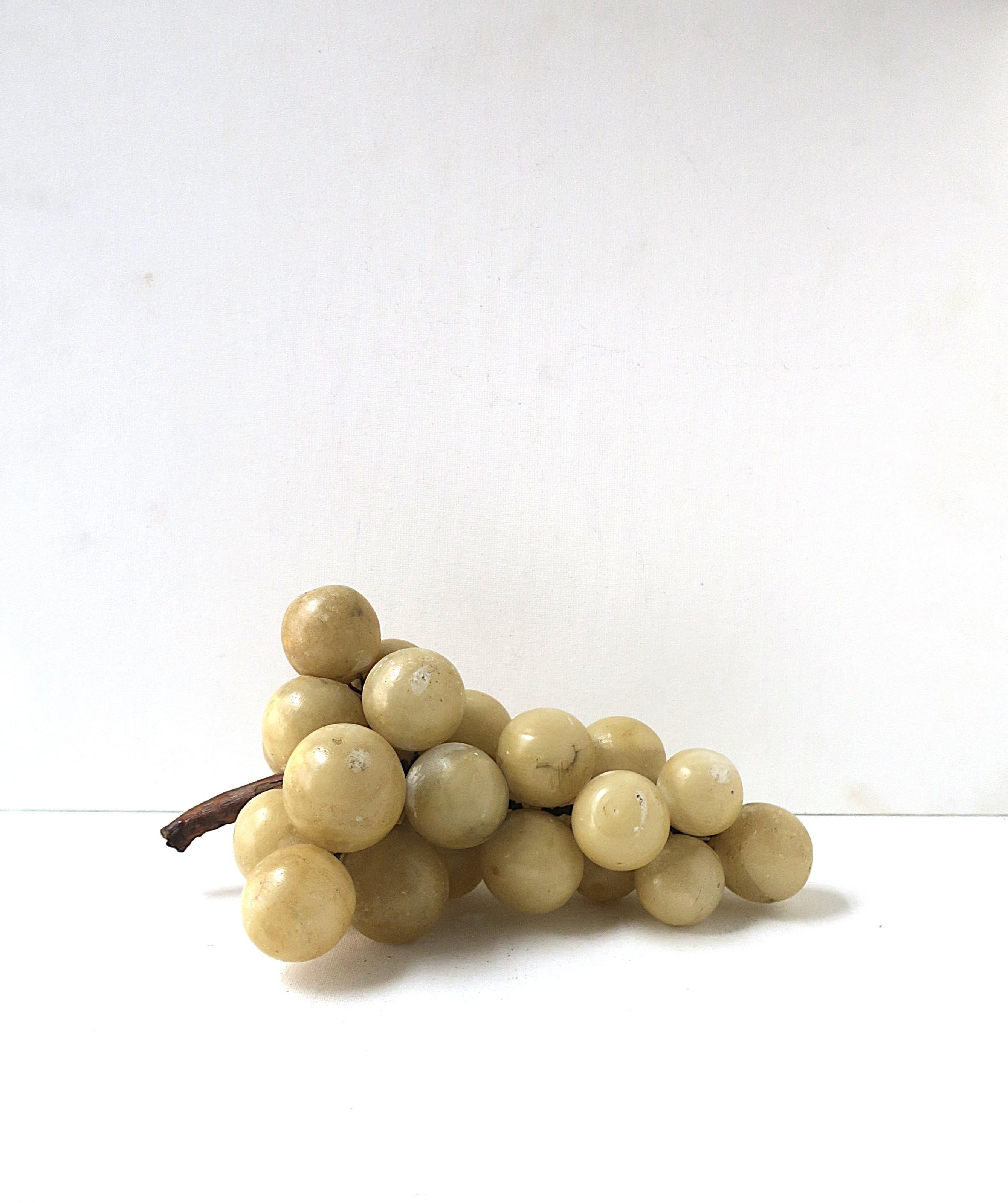 A beautiful 'bunch' of Italian alabaster marble grapes with wood vine, in the Modern/Organic Modern style, circa early to mid-20th century, Italy. Alabaster marble grapes are hand-carved/polished attached to a natural wood vine. A substantial bunch