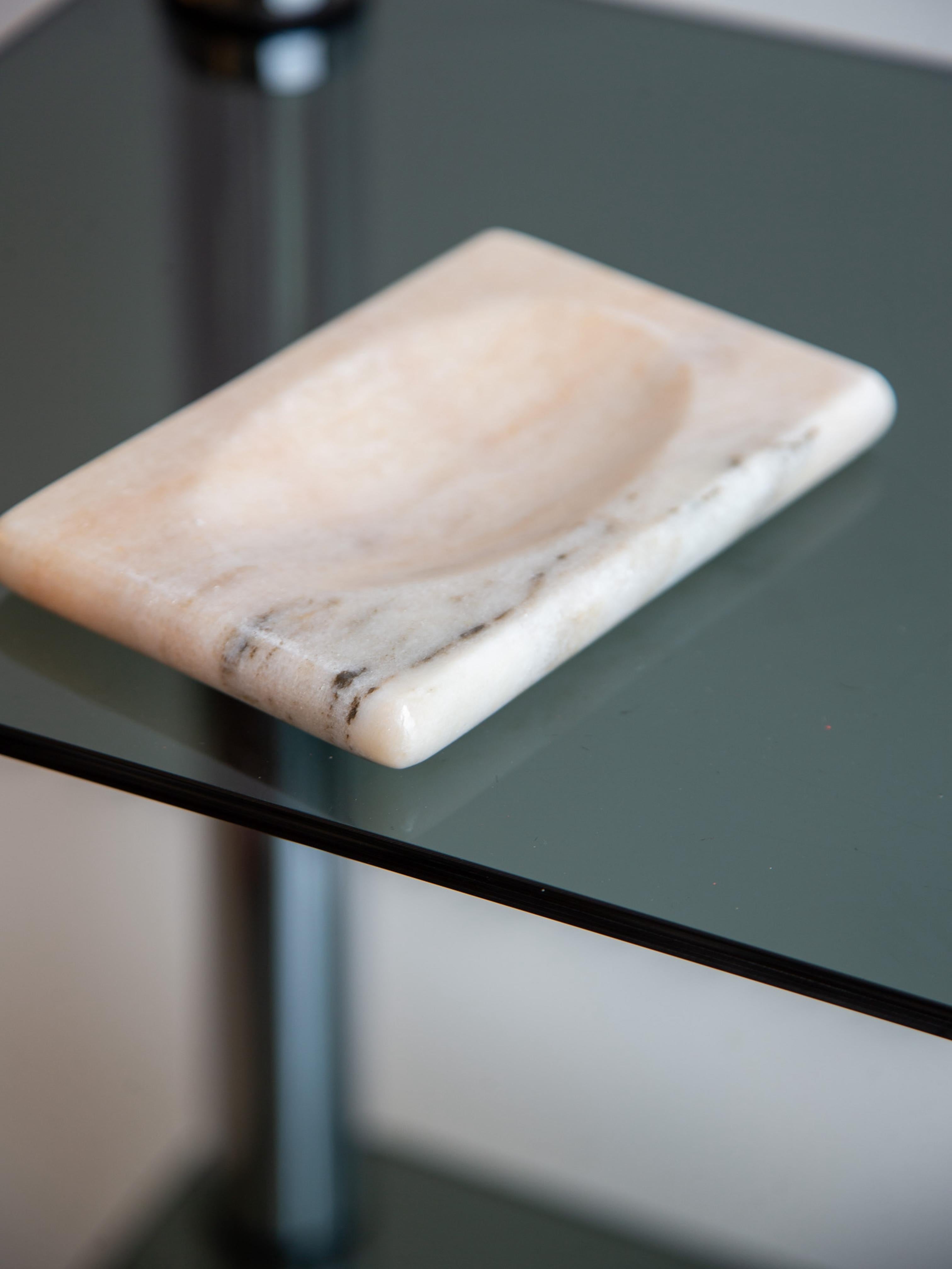 Un sculptural porte-savon en marbre italien des années 1970, élégamment sculpté avec une sensibilité minimaliste. La forme rectangulaire est adoucie par des coins légèrement arrondis et un centre concave peu profond, parfaitement conçu pour