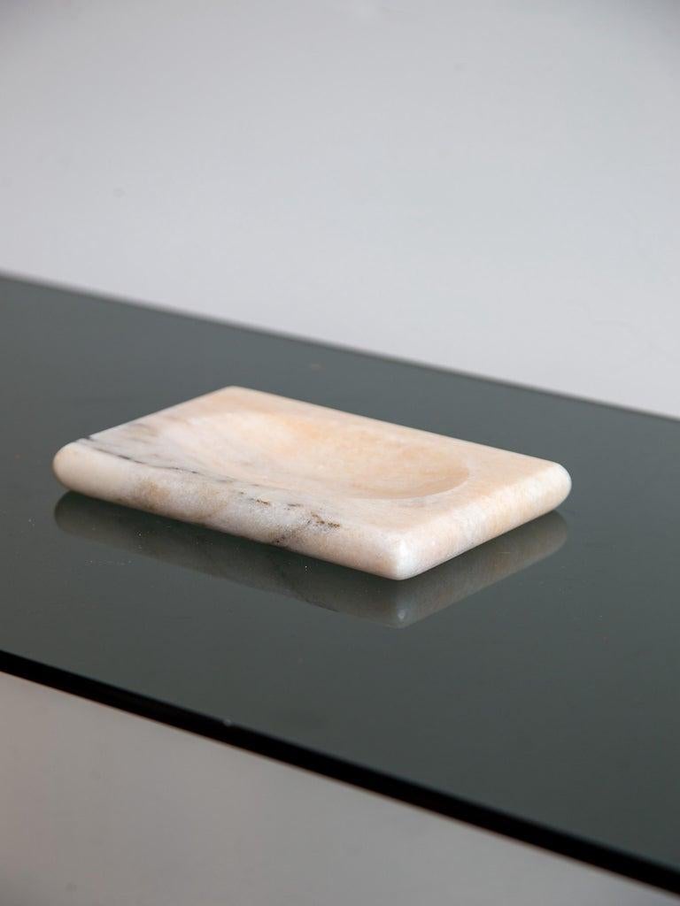 Eine skulpturale Seifenschale aus italienischem Marmor aus den 1970er Jahren, elegant geschnitzt mit minimalistischer Sensibilität. Die rechteckige Form wird durch sanft abgerundete Ecken und eine flache, konkave Mitte aufgelockert, die sich perfekt