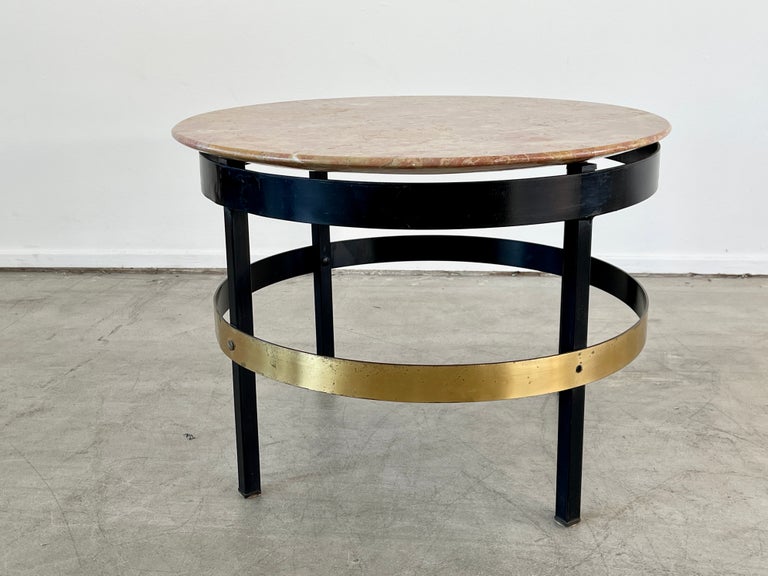Italian side table with pink marble table sitting on black iron base with brass flat bar concentric circle stretcher.