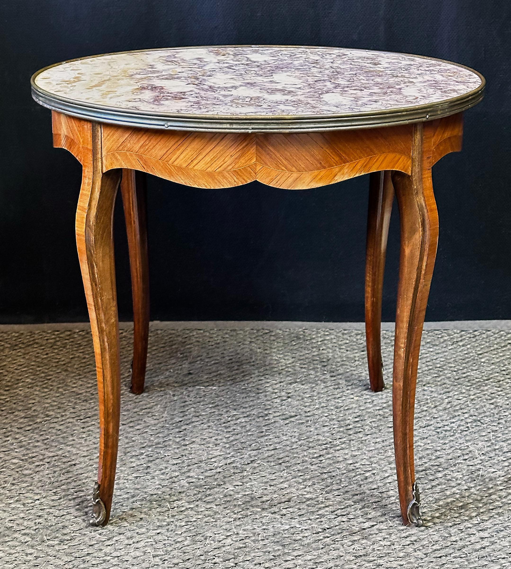 20th Century Italian side table with a beautiful round marble top having a molded outer edge of brass. The marble is in rare hues of violet, gold, and white and possibly from the Seravezza quarry of the Tuscan Alps. The top rests on a recessed apron