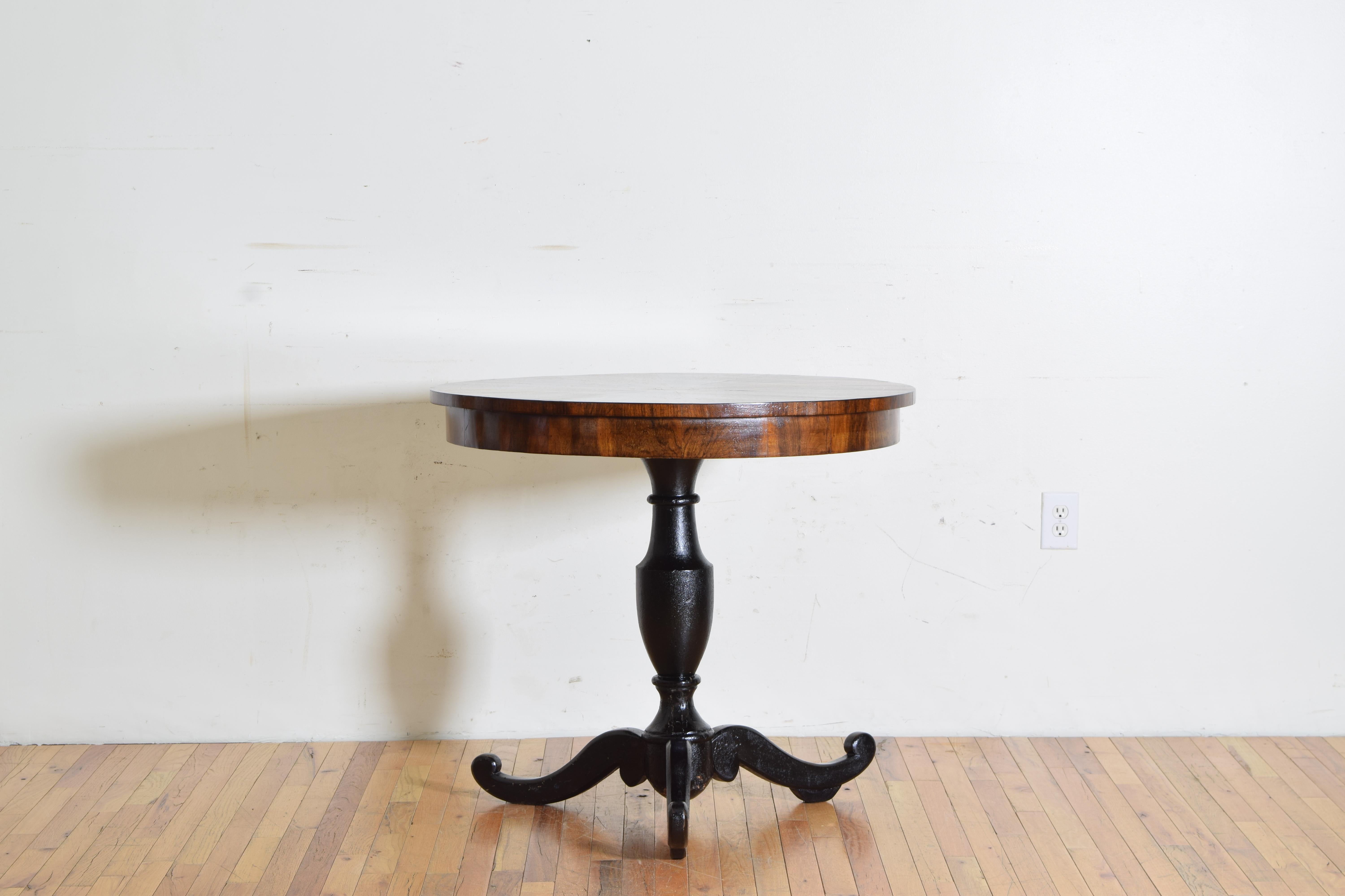 The top comprised of 12 pie shaped pieces of veneer radiating from a centrally inlaid circle with 4 concentric lozenge forms all in a lighter fruitwood with a thin radial outer band of lighter fruitwood, possibly a bleached walnut, the apron with