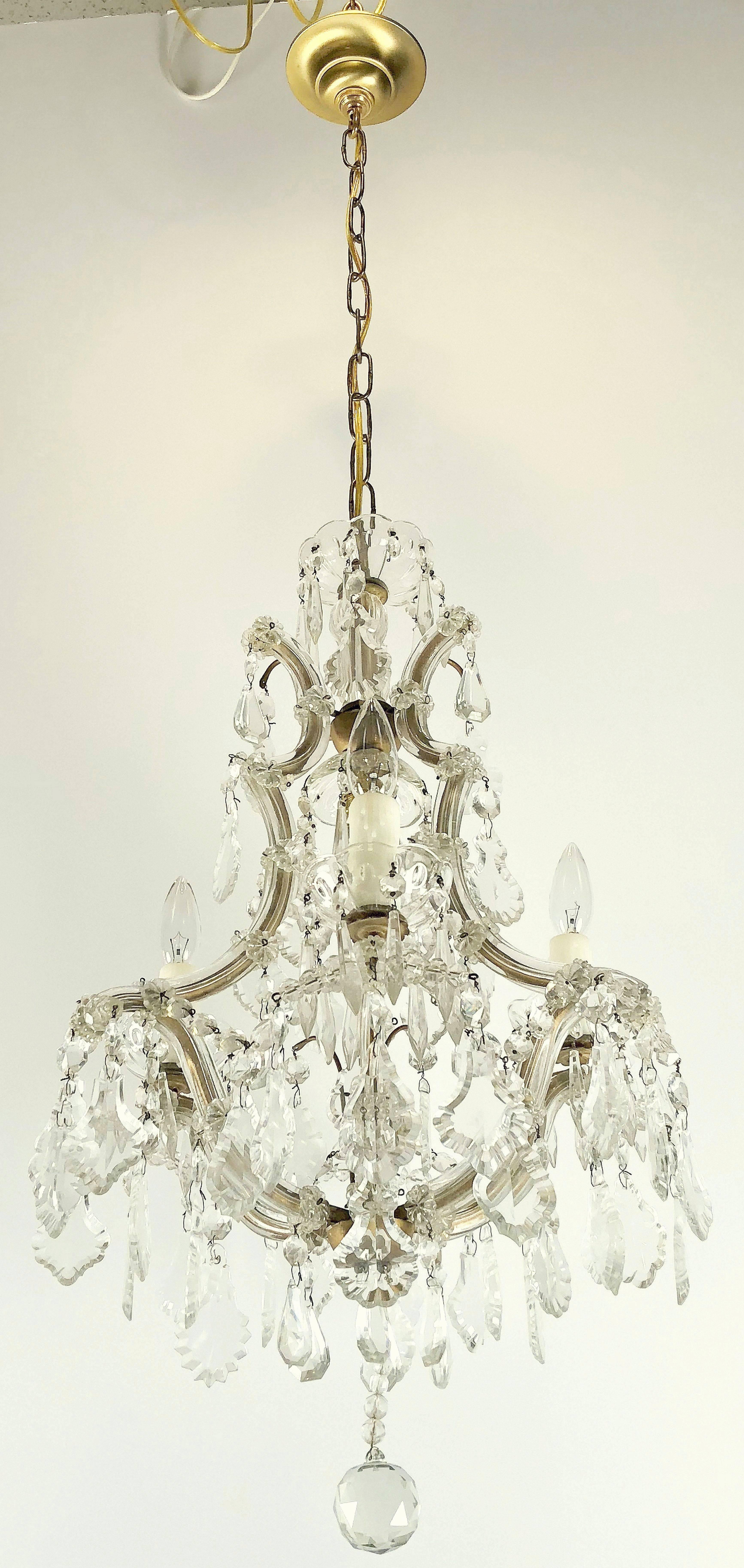 A fine Maria Theresa four-light chandelier (or hanging fixture) of crystal, glass and gilt metal featuring serpentine arms, each candle light with dangling pendants and decorative bobeches.

Measures: 17 inches diameter

U.S. wired and ready for