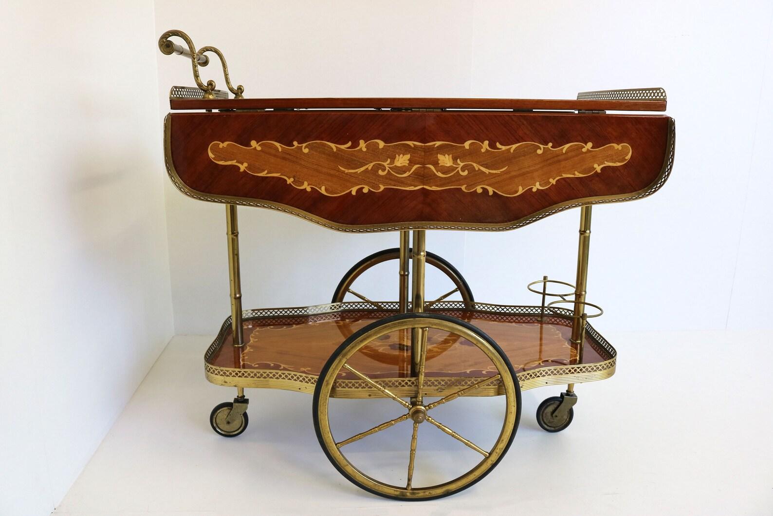 This is a stunning 1950's entertainer’s bar cart from Italy. It has this amazing look & feel of luxury and class. 
Great for displaying your bar set, or a wonderful item to roll out with your pastries and tea sets. The cast brass wheels move easily