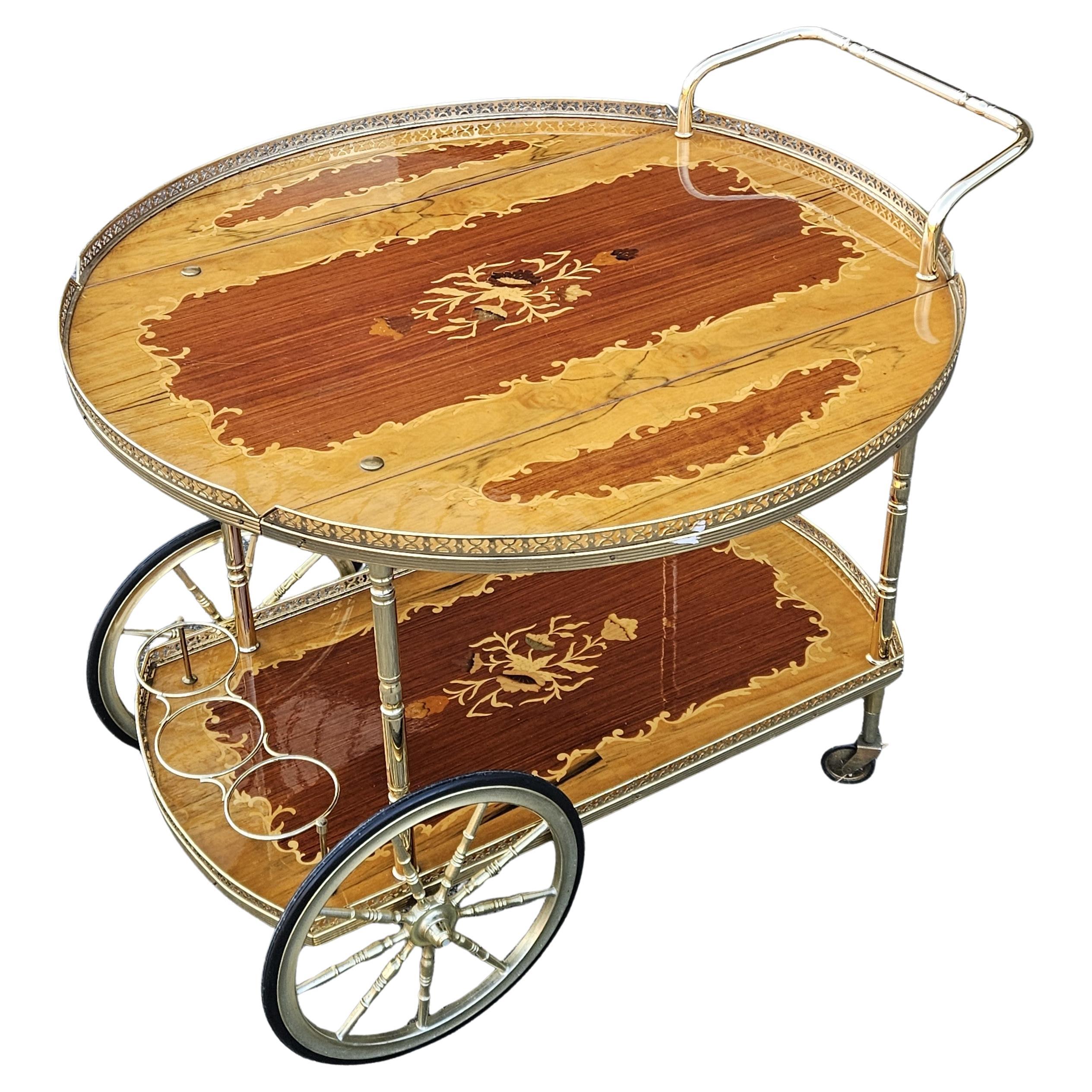 Beautiful Italian Neoclassical inlaid Marquetry Dessert - Bar Cart with Brass Accent and Drop Leaves.
Bar cart in Neoclassical Design - made from fine Woods and Brass.
Magnificent Marquetry in multiple Colors on the Serving Surfaces.
Sealed with a