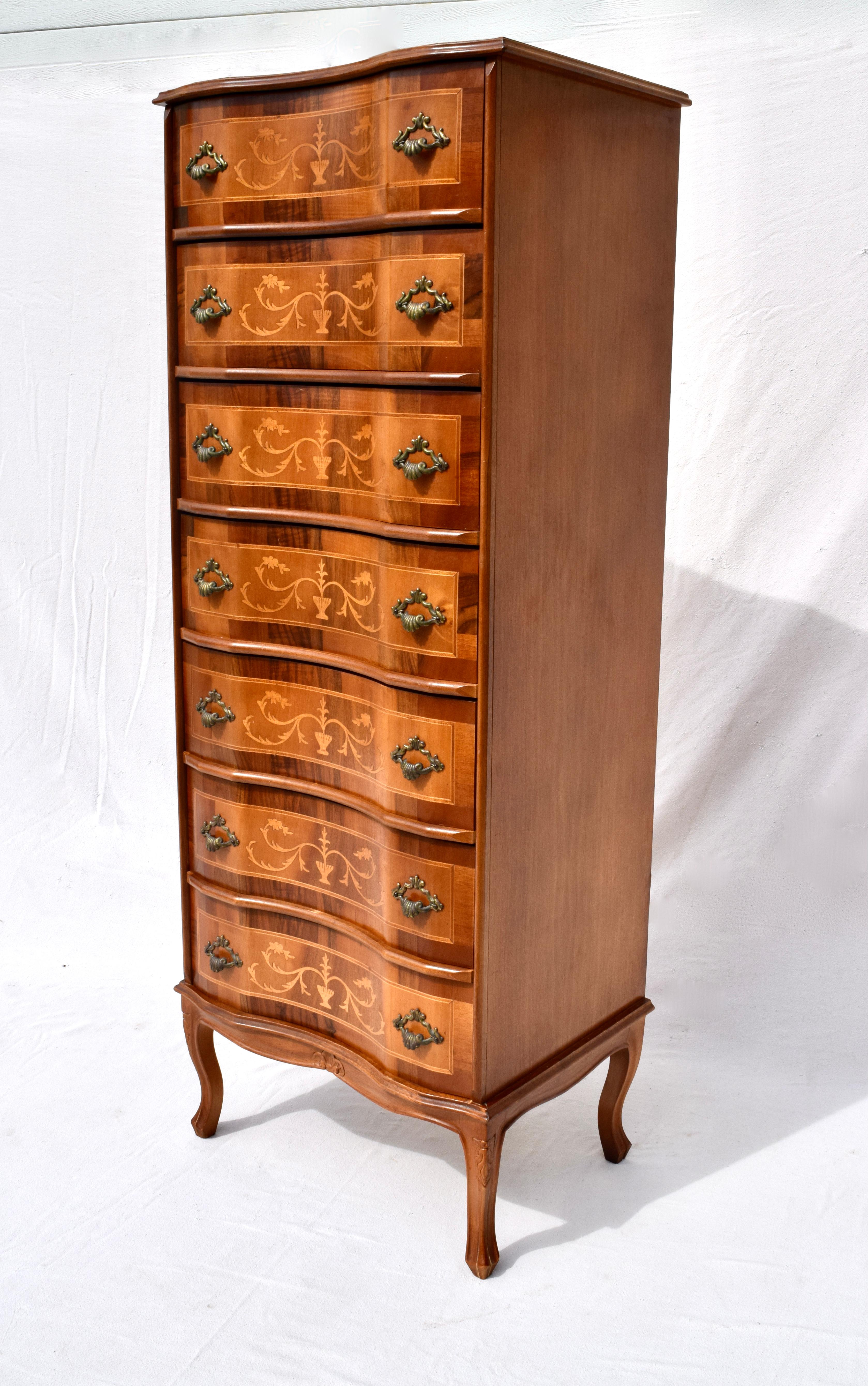 French styling chest of seven dovetailed walnut and satin wood drawers with inlays of scroll foliage designs. Serpentine front with patinated bronze Rocaille shell style handles. Striking yet reasonable in size suitable for a variety of uses &