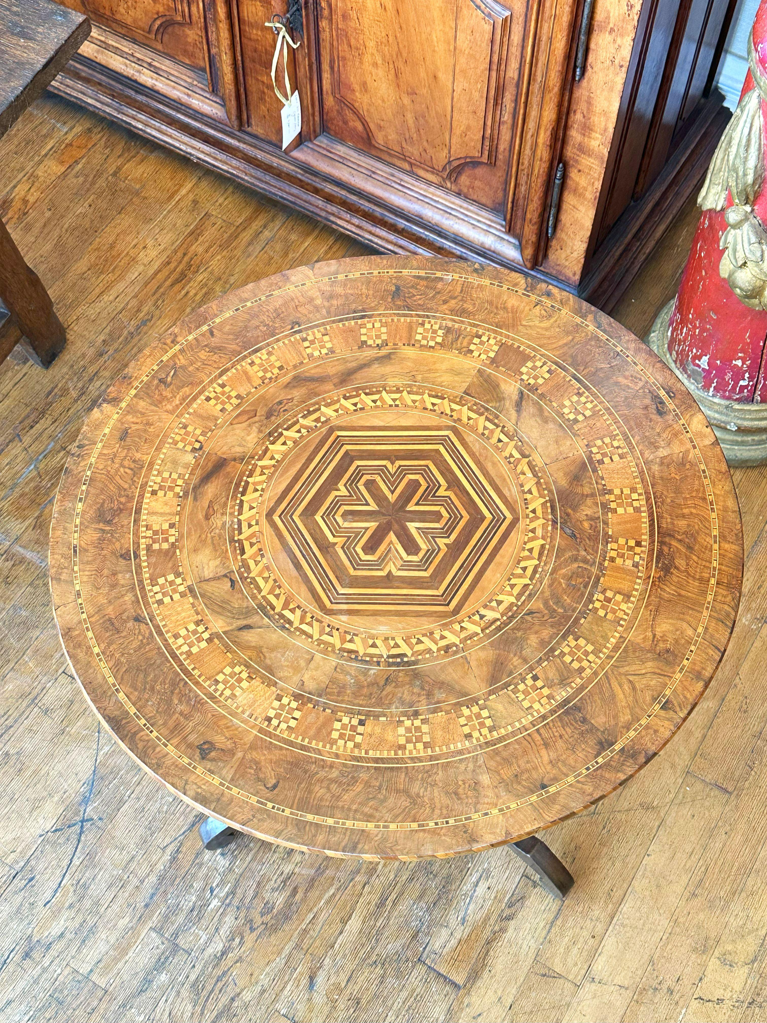 Circular marquetry inlaid top raised on a baluster turned support resting on a tripartite base with slightly under scrolled feet. 