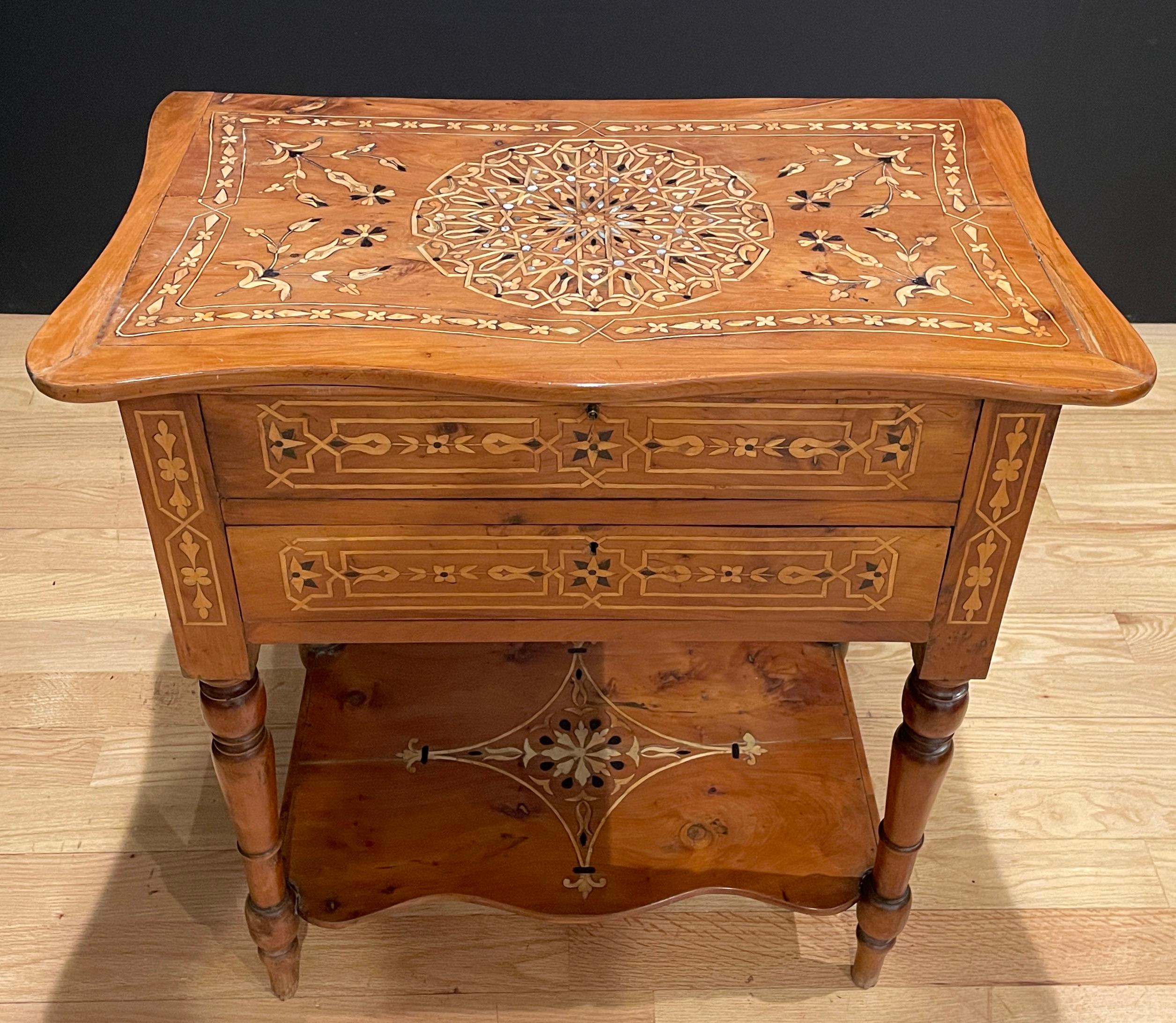Fine quality Italian work table of light walnut with marquetry inlay of ebony, pear wood and abalone/mother-of-pearl. Lift top with one draw and bottom shelf with turned legs.
