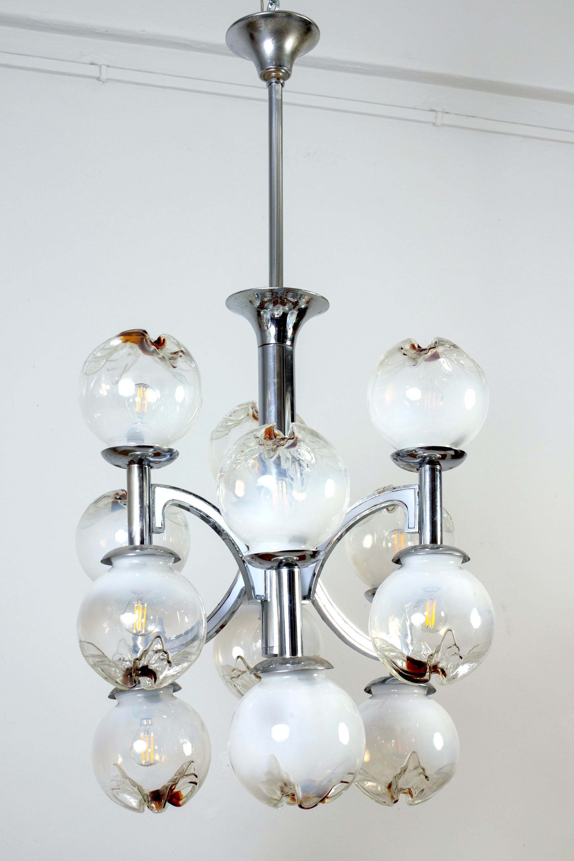 This stunning 12 lights chandelier with rare handblown  Murano glass balls and chrome metal fixture.
Original tested electrical system working but we can rewired for US standard system.
 Twelve E 14 light bulbs.
Cleaned and re-wired, in full working