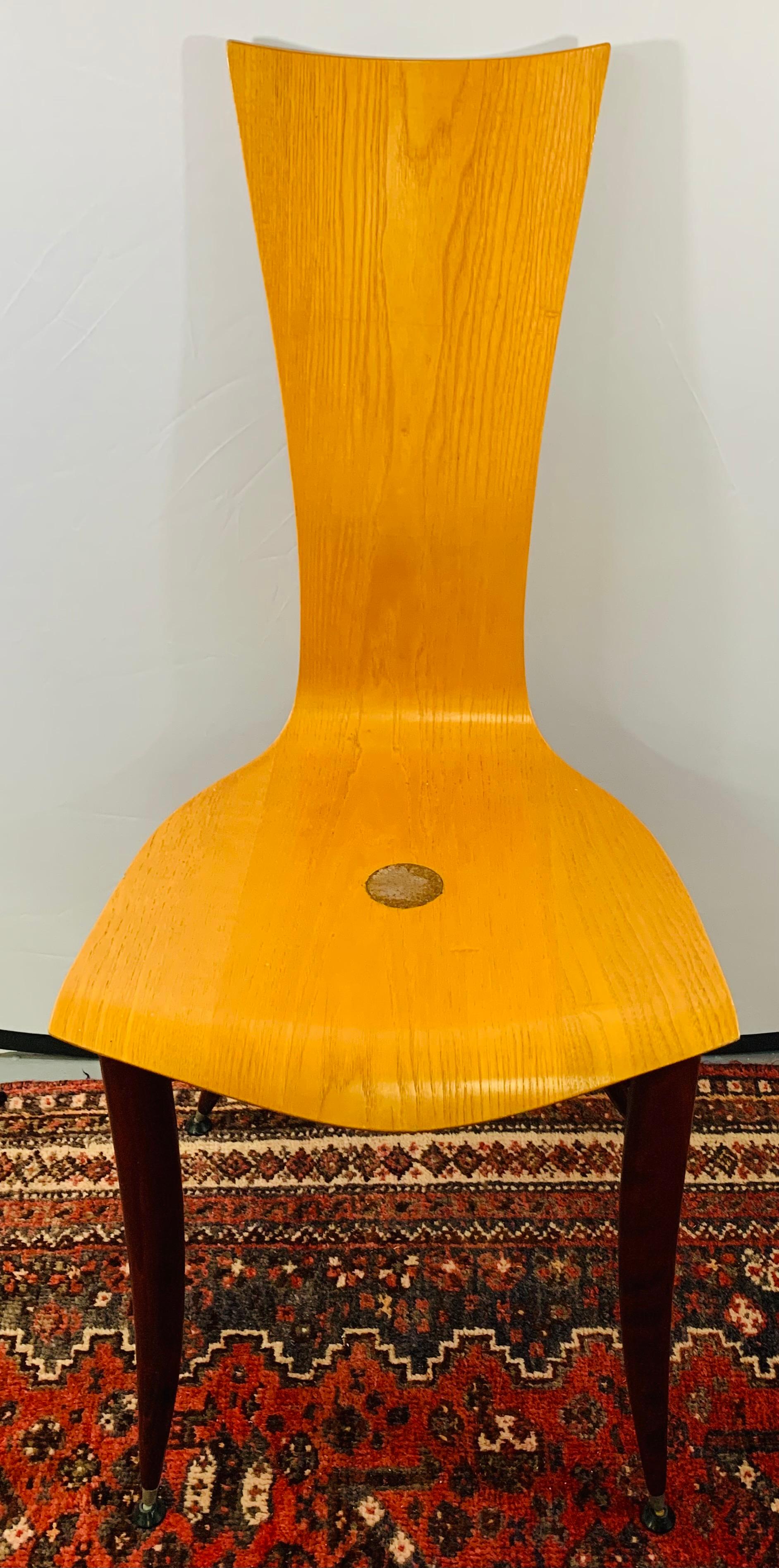 A stylish pair of Mid-Century Modern wooden chairs in the manner of the Italian designer Umberto Mascagni. The legs are finely painted in cherrywood color and are beautifully carved. The wood is in good condition with some minor fading as shown on