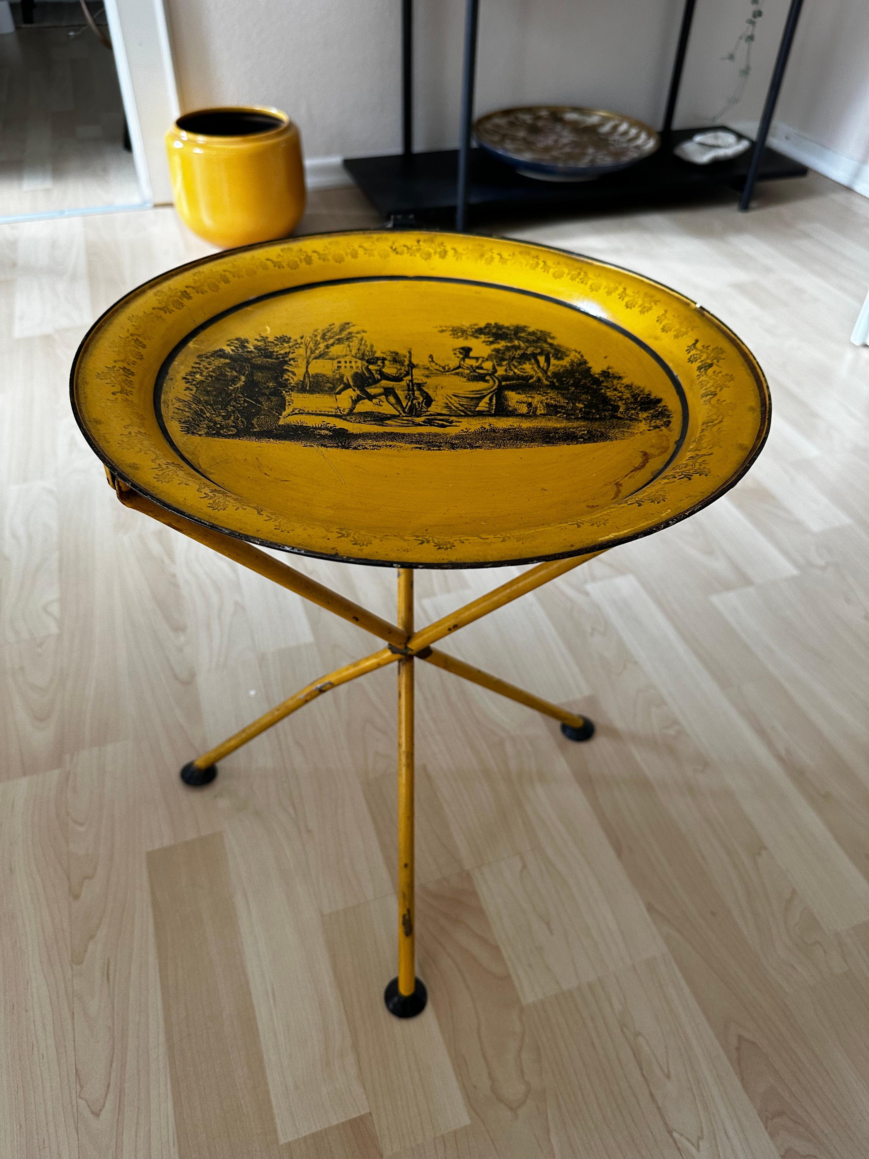 Transport your living space back to the opulent Empire era with this Italian folding table crafted from metal, dating back to around 1970. The Empire style was known for its extensive use of metalwork, and the intricate paintings on metalware, such