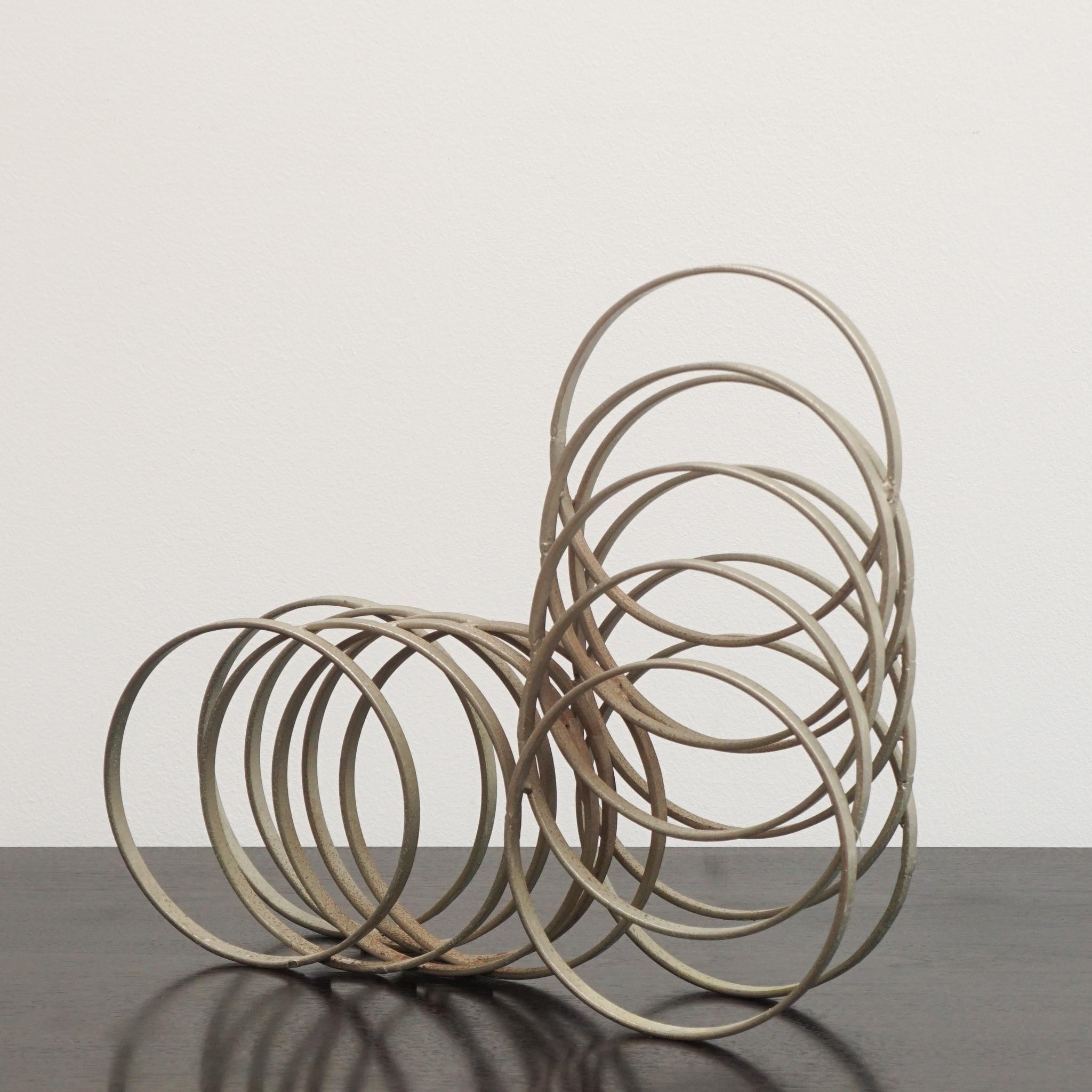 Metal rings were used to create the unusual stepped sculpture, shown here, from Italy c. 1970s.   Arranged in ascending and descending order, the coils are soldered in place to create a free-standing vertical or horizontal work of art.  