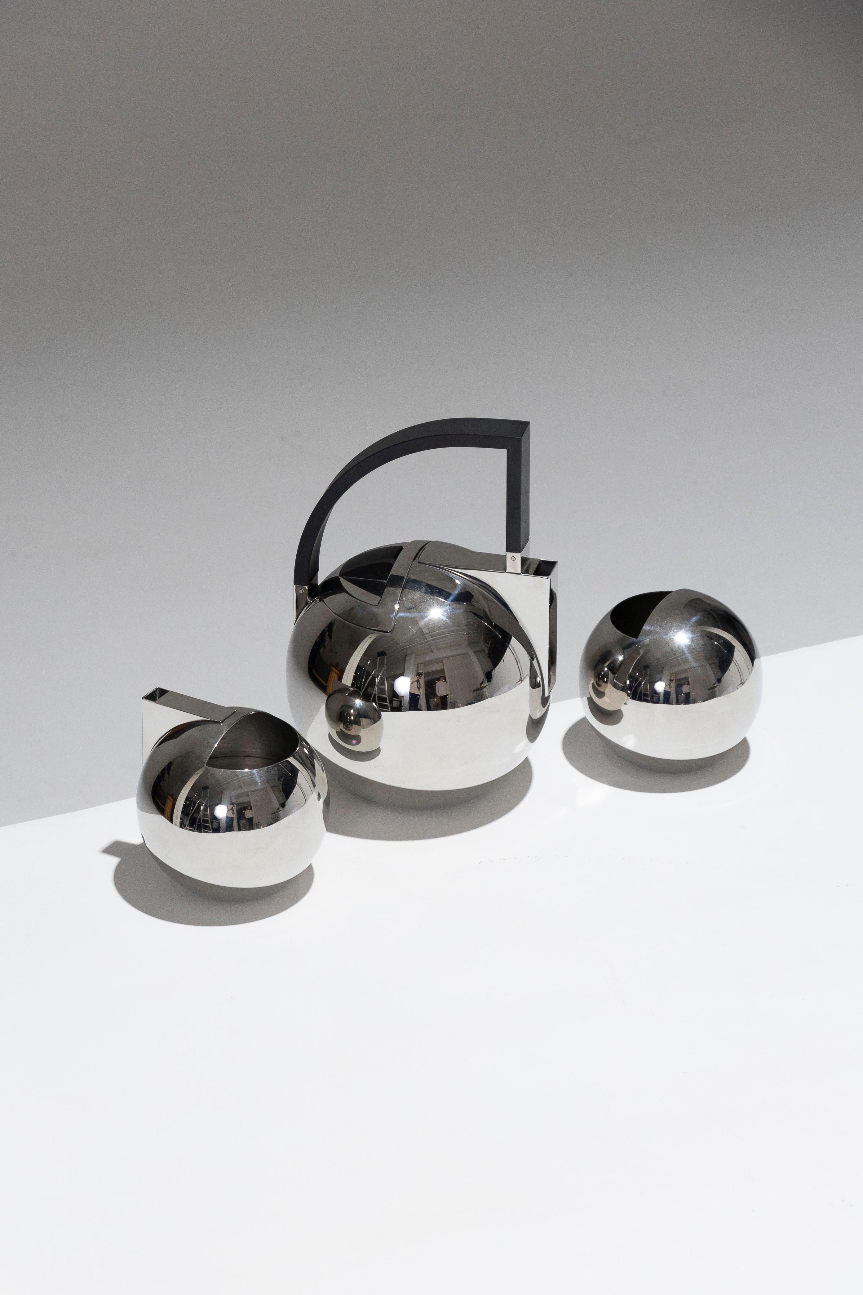 This elegant tea set by Olivier Hemming showcases the refined Italian design of the 1980s. Comprising a teapot, sugar bowl, and milk jug, the pieces feature rounded, minimalist shapes characteristic of the era. The black polymer handle adds a modern