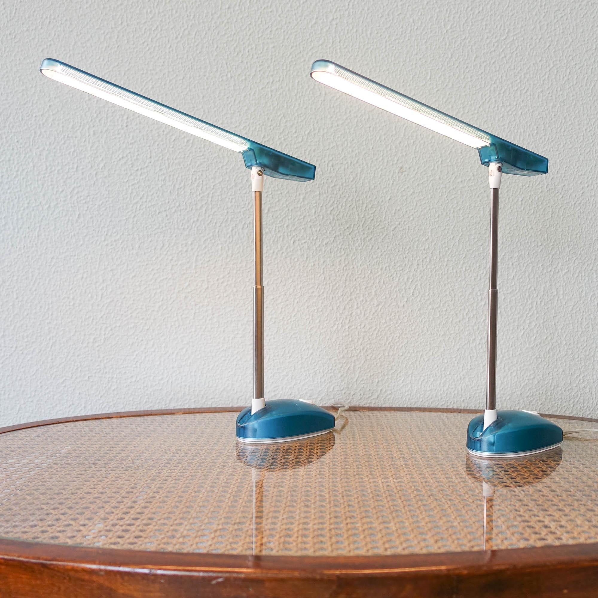 Cette paire de lampes de table, modèle Microlight, a été conçue par Ernesto Gismondi pour Artemide, dans les années 1990. Il s'agit d'un design très technique des années 90. Cette lampe de table flexible est prédestinée aux postes de travail sur