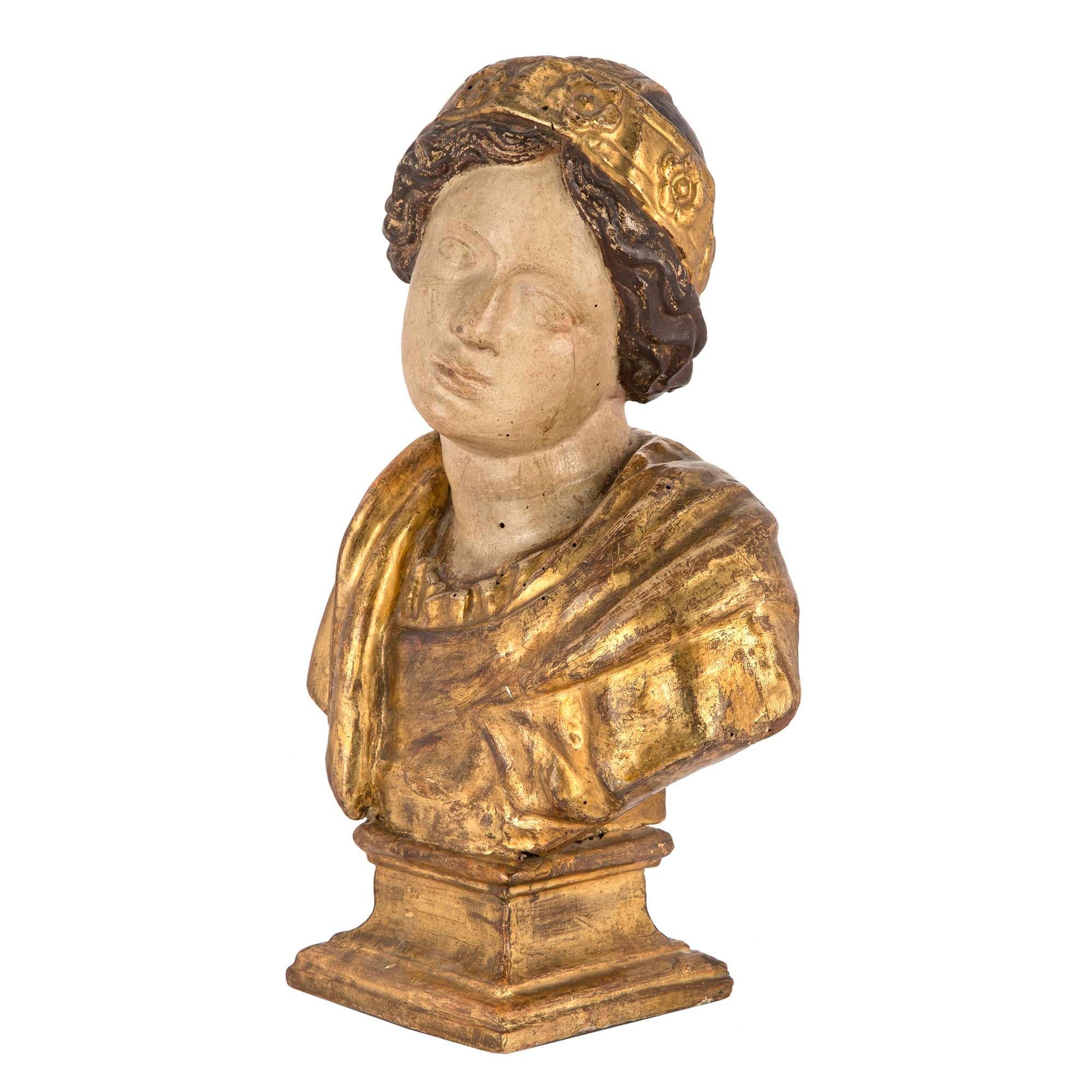A very handsome Italian mid-17th century Baroque period giltwood and polychrome bust. The bust of an Italian scholar is raised on a giltwood rectangular mottled base. Shown with a giltwood classical drape below the polychrome face and neck. The bust