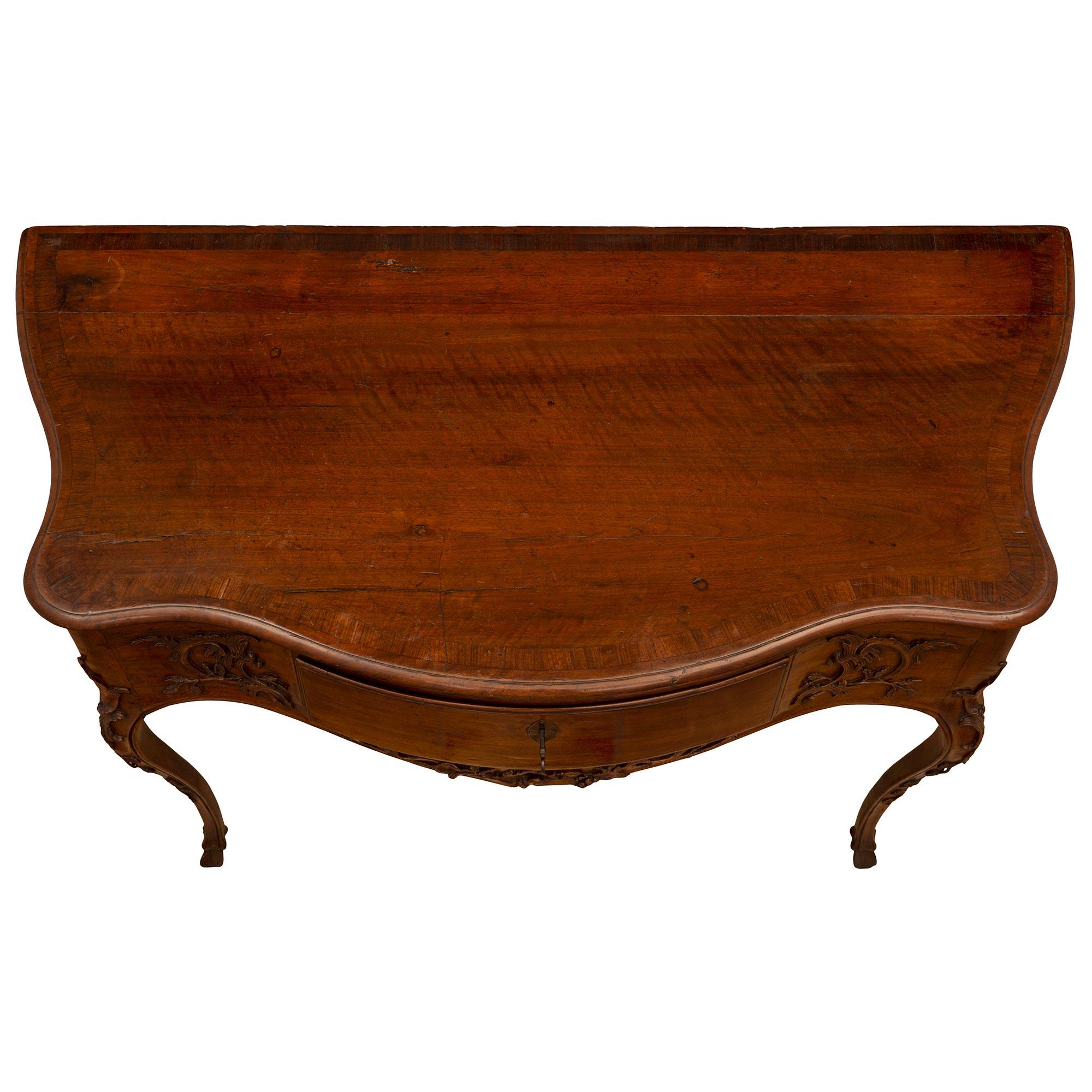 A most elegant and high quality Italian mid 18th century Louis XV period walnut console. The freestanding console is raised by beautiful slender cabriole legs with hoof feet and charming finely detailed foliate carvings. The deep arbalest shaped