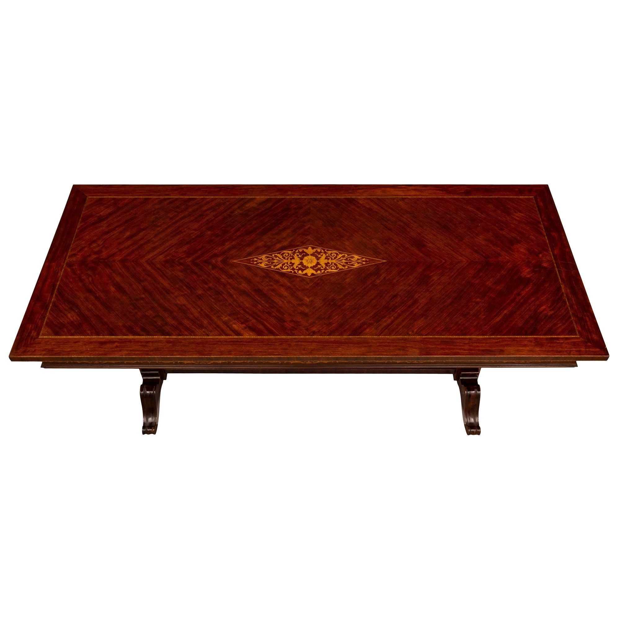 Belle table centrale italienne néo-classique du milieu du XIXe siècle en acajou et bois de tulipier. La table rectangulaire est surélevée par de beaux supports coniques carrés avec de beaux motifs feuillagés incrustés et des masques avec des paniers