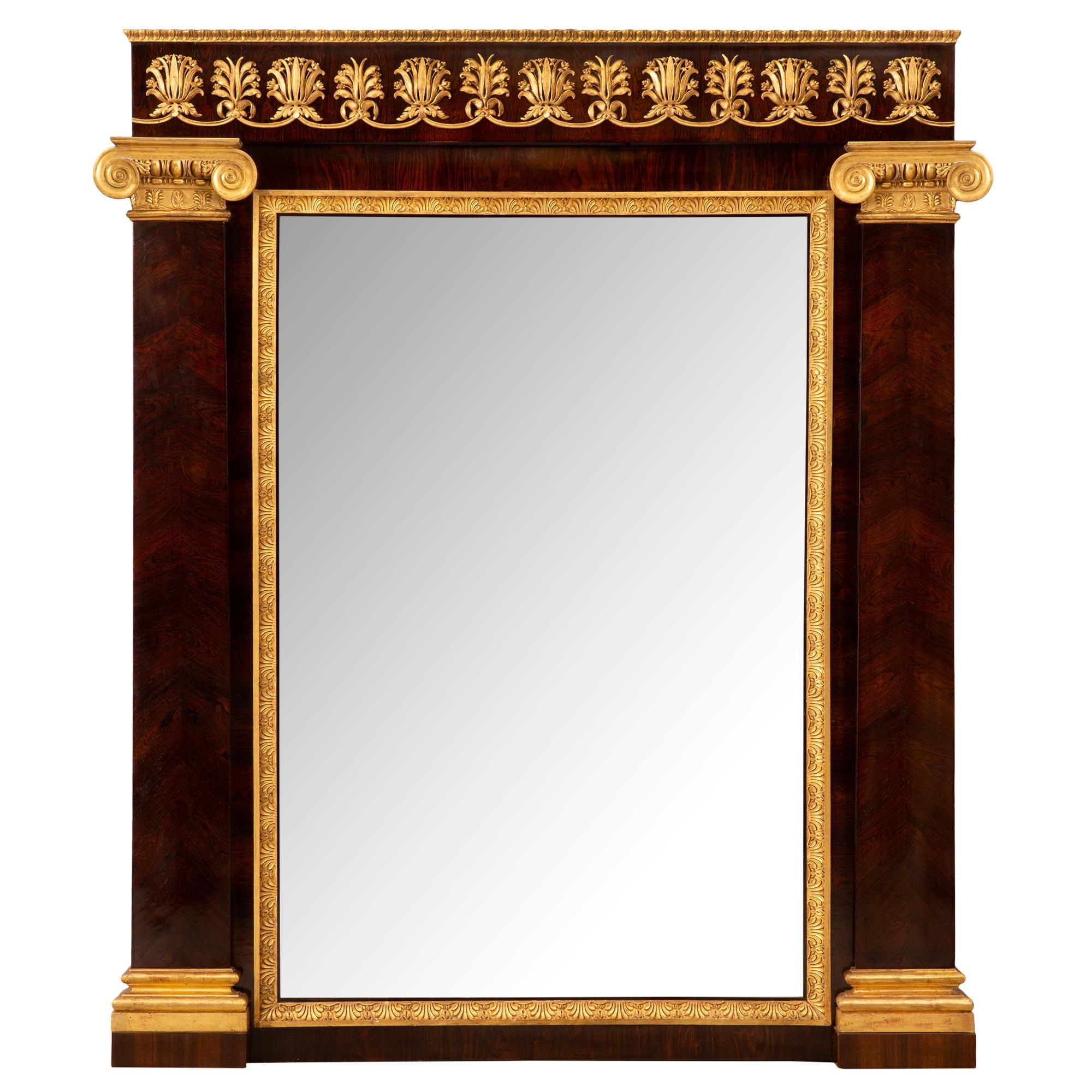 A handsome and high quality Italian mid 19th century neo-classical st. rosewood and giltwood mirror. The mirror plate is set within a beautiful and most decorative mottled giltwood band with striking palmettes designs. Leading up each side are