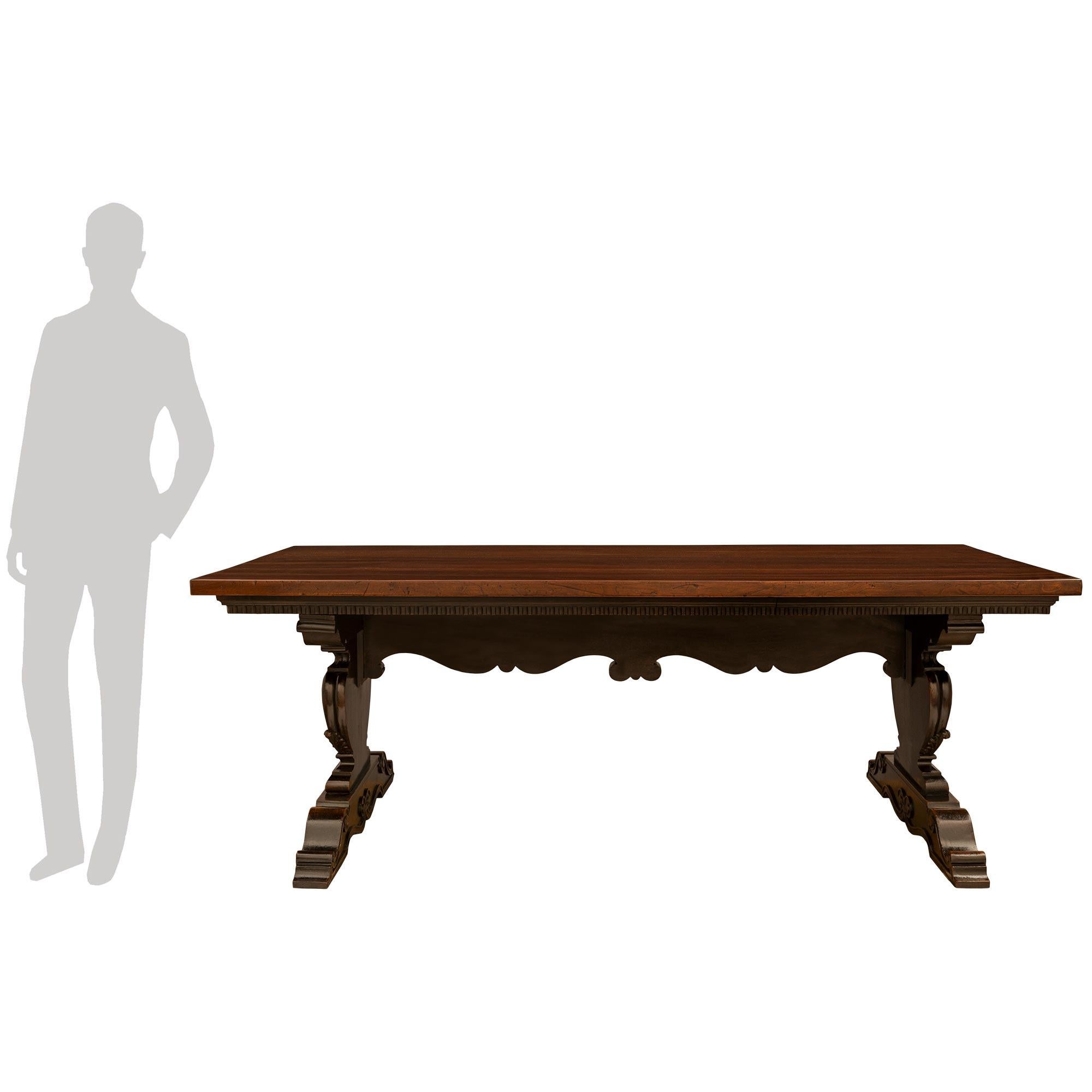 Magnifique table à tréteaux en noyer de style toscan du milieu du XIXe siècle. Cette magnifique table repose sur des supports sculptés extrêmement décoratifs avec des volutes en 