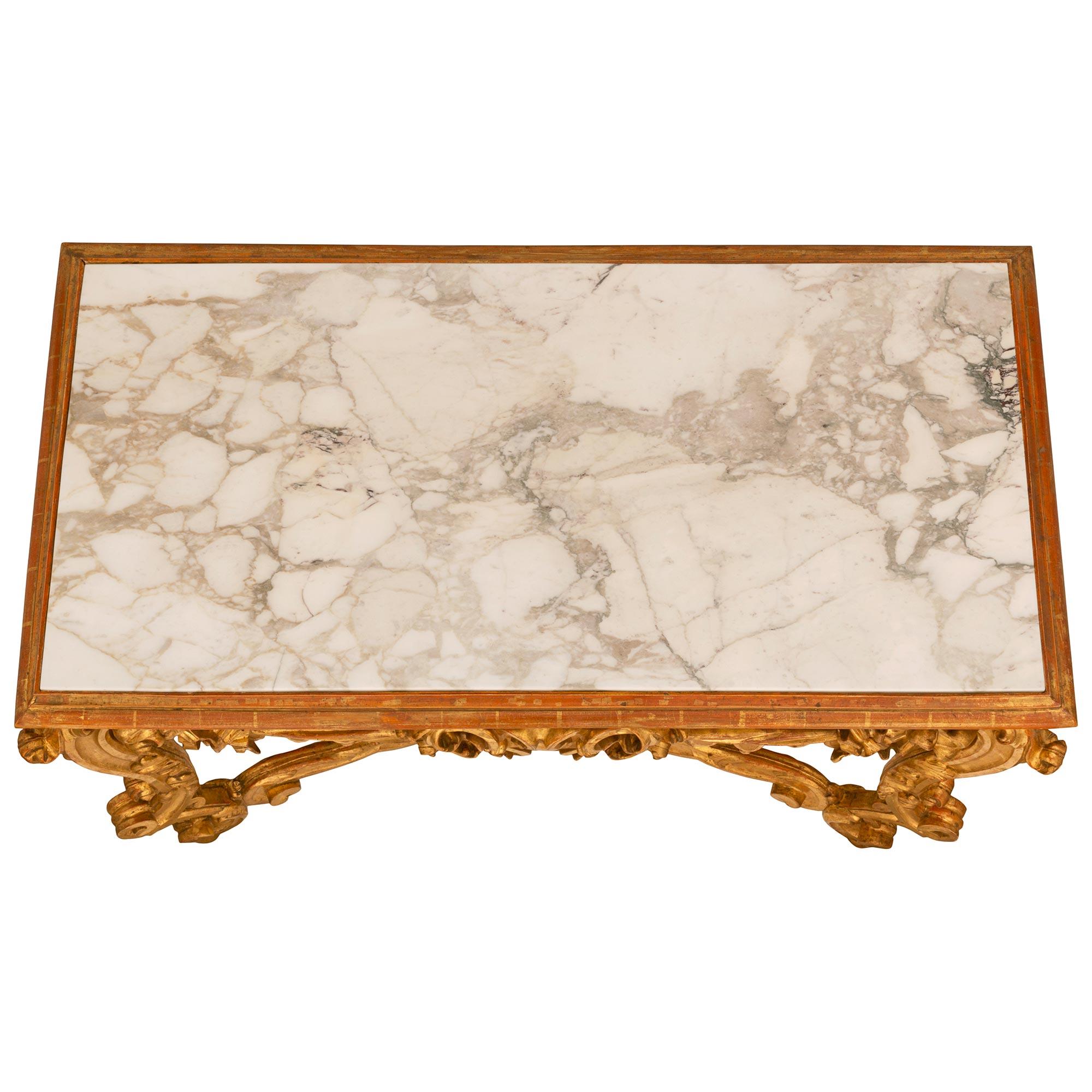 An impressive and large scale Italian mid 19th century Venetian giltwood and marble freestanding console. The console is raised by wonderful and richly carved scrolled legs with a recessed design and adorned with large acanthus leaf carvings. The