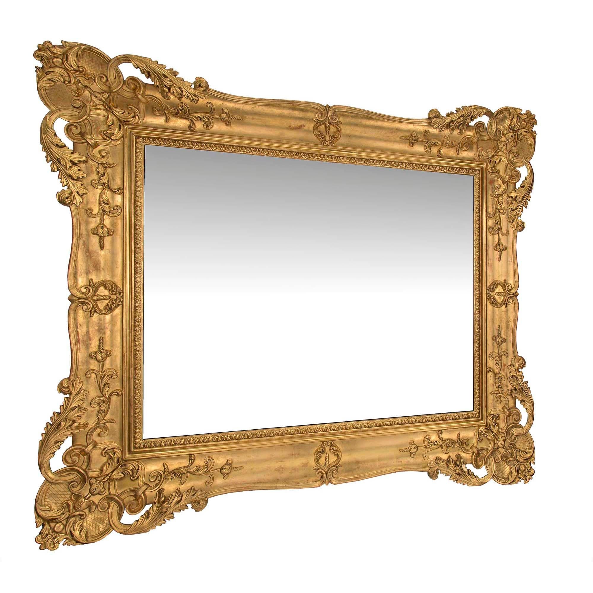 Superbe miroir rectangulaire vénitien italien du milieu du XIXe siècle. La plaque de miroir d'origine est encadrée d'une impressionnante bordure en bois doré à motif de feuillage et à motif moucheté. Le cadre lisse affiche une finition brûlée chaude