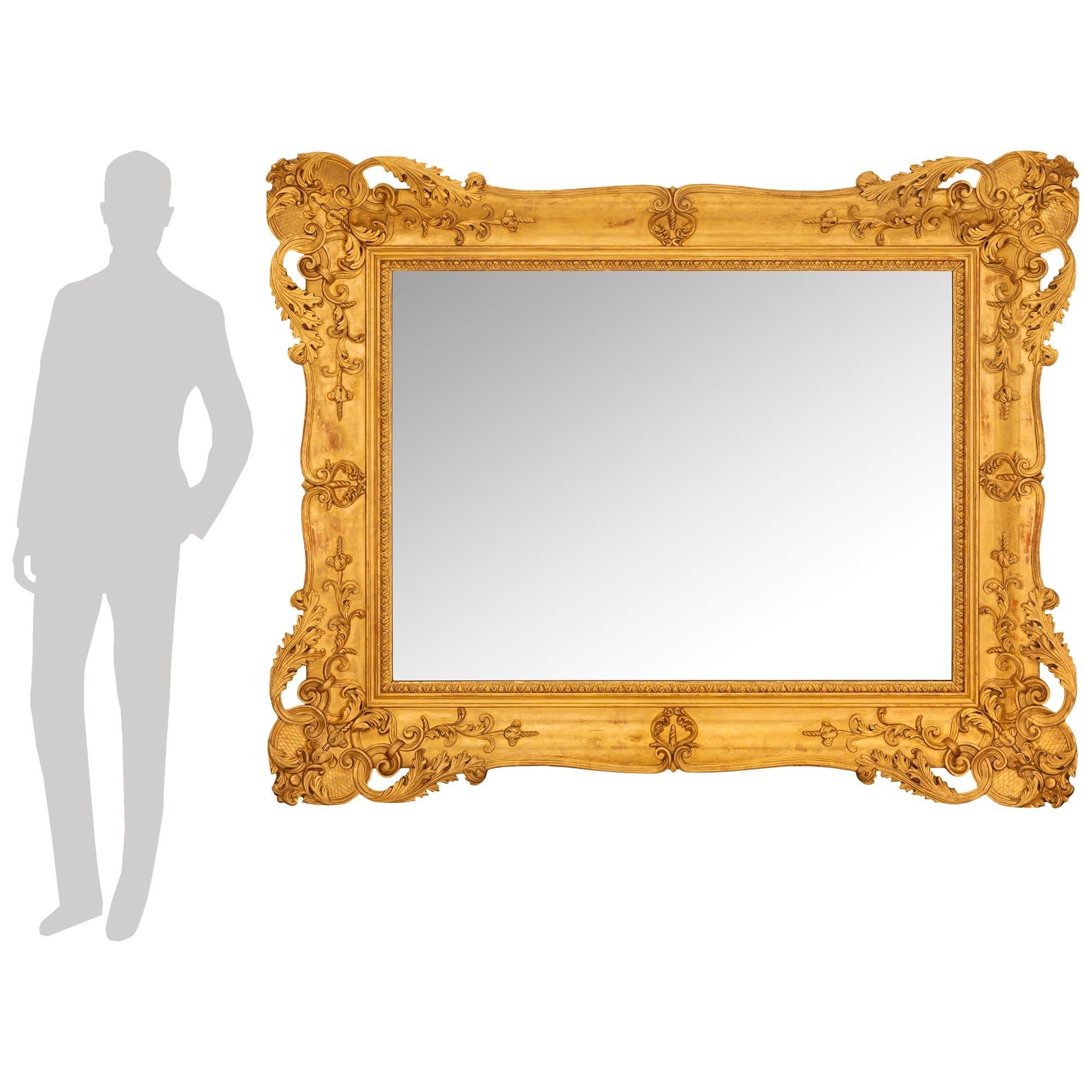 A stunning and most elegant Italian mid 19th century Venetian st. Giltwood mirror. The original mirror plate is framed within a most impressive Giltwood border with a foliate motif and mottled design. The smooth frame displays a warm satin and