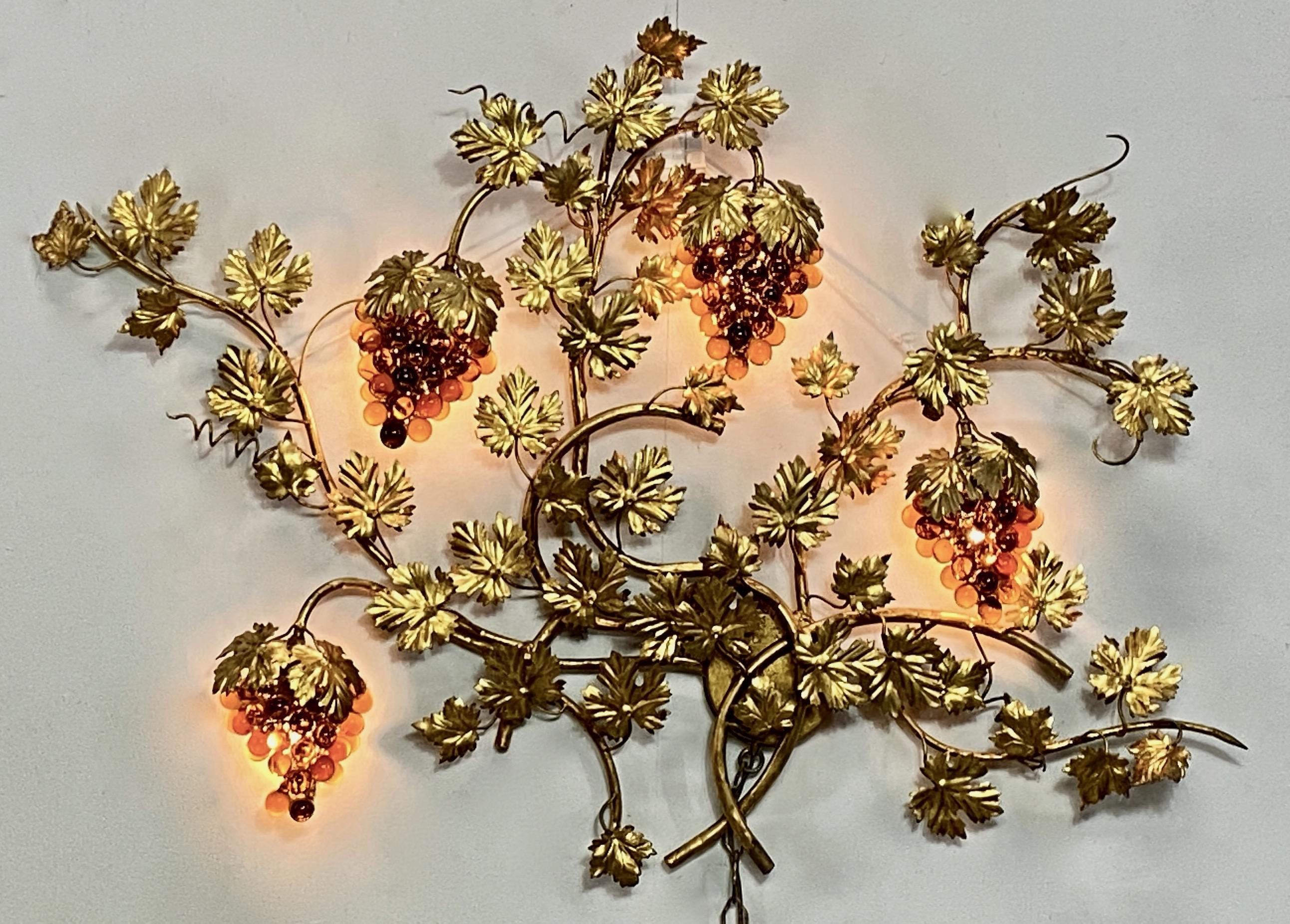 Unusual mid- 20th century Italian amber glass and brass grapevine wall light with glowing grape clusters.